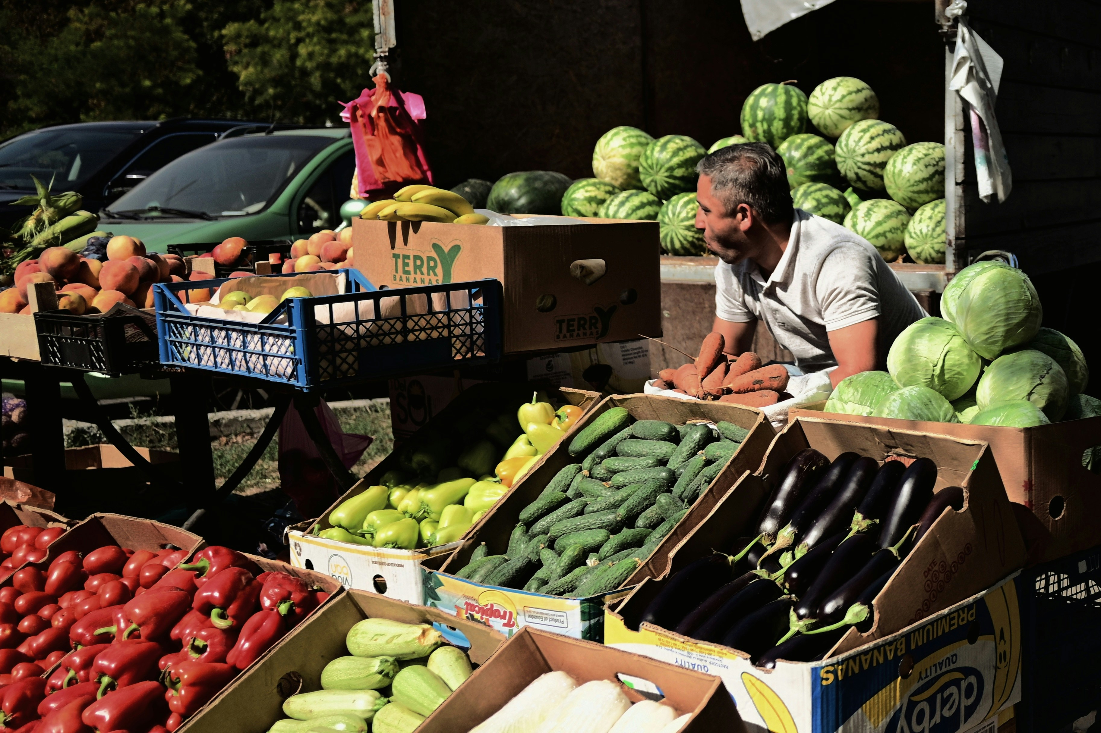 Man selling fresh produce at an outdoor market.