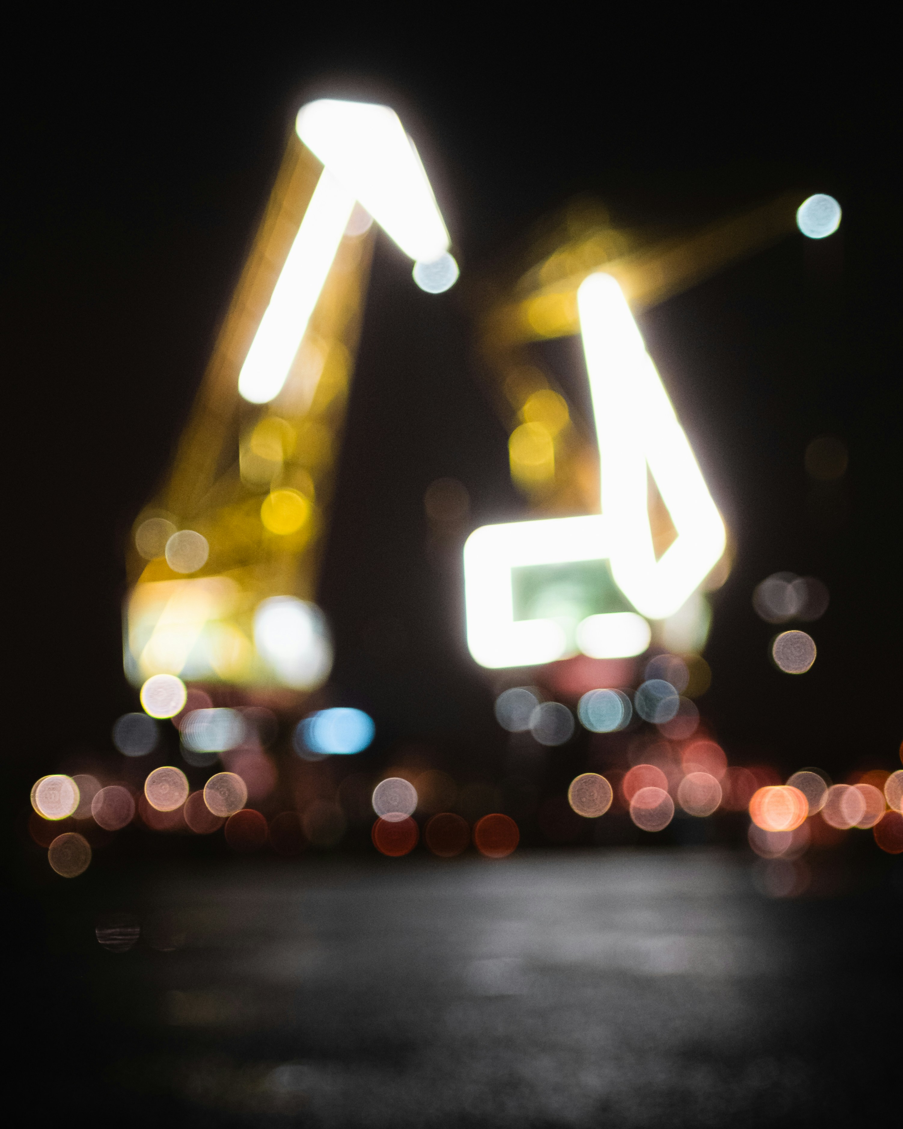 Grúas borrosas iluminadas por la noche con luces bokeh