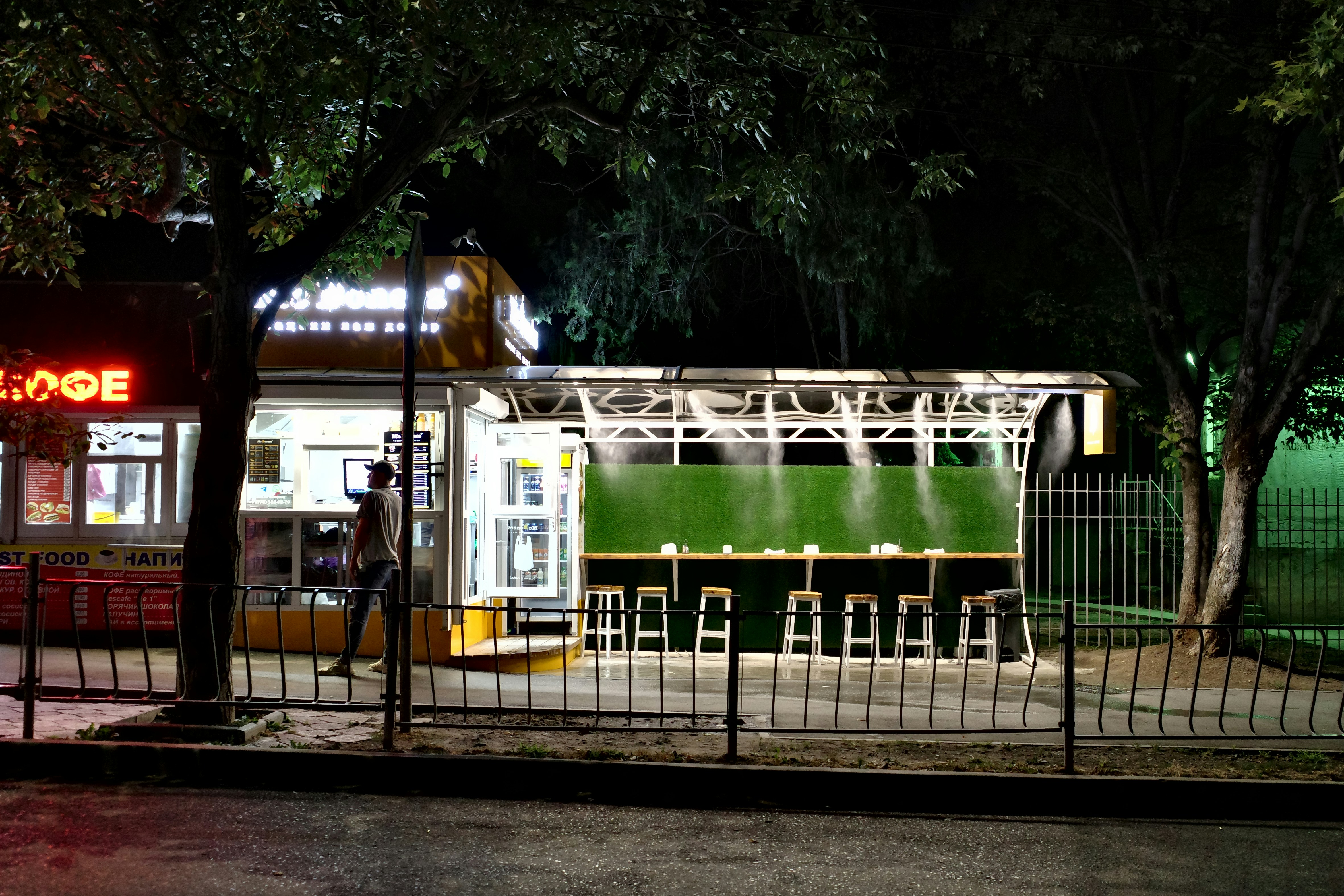 A small food stall at night with outdoor seating.