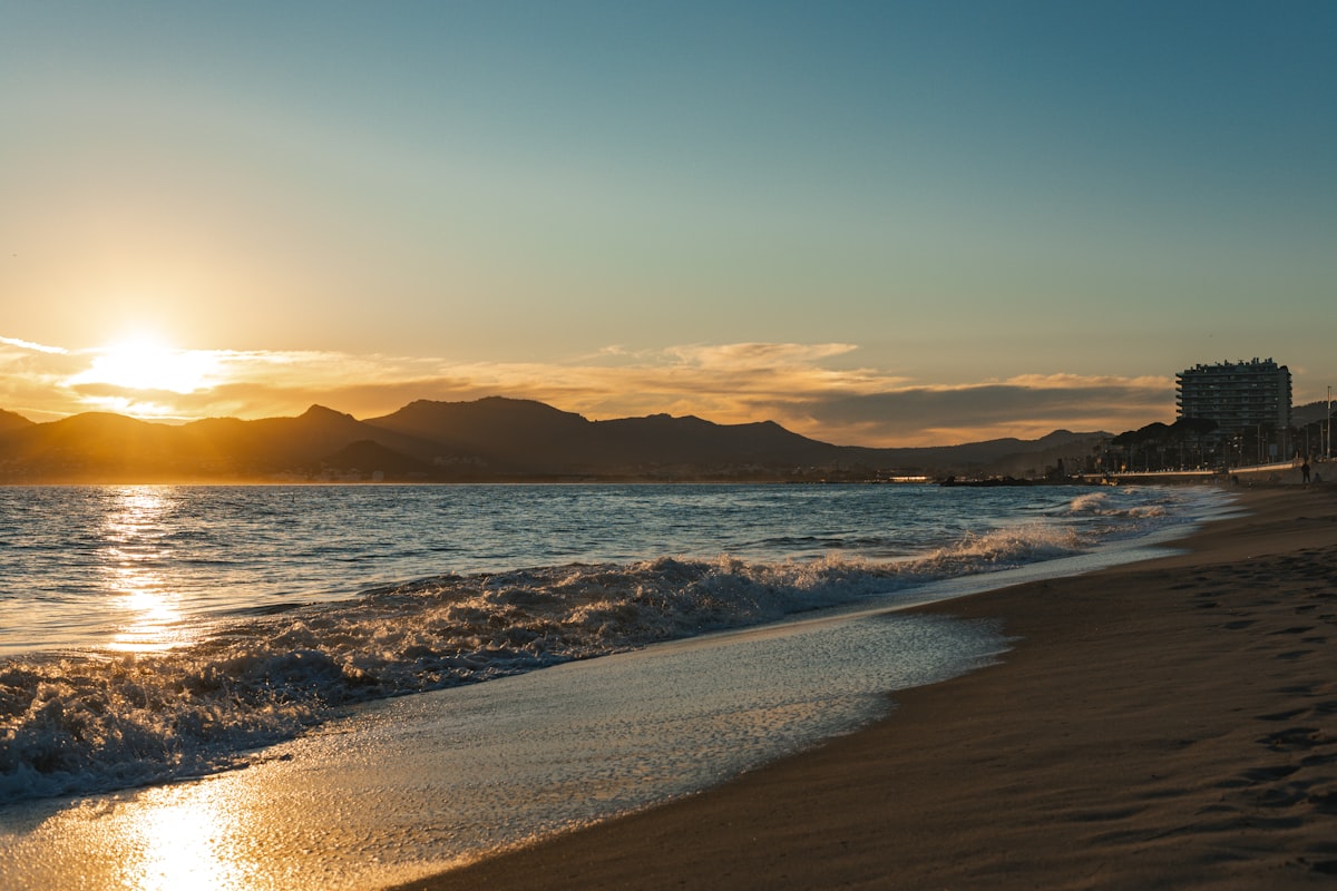 Sunset over a calm ocean with mountains
