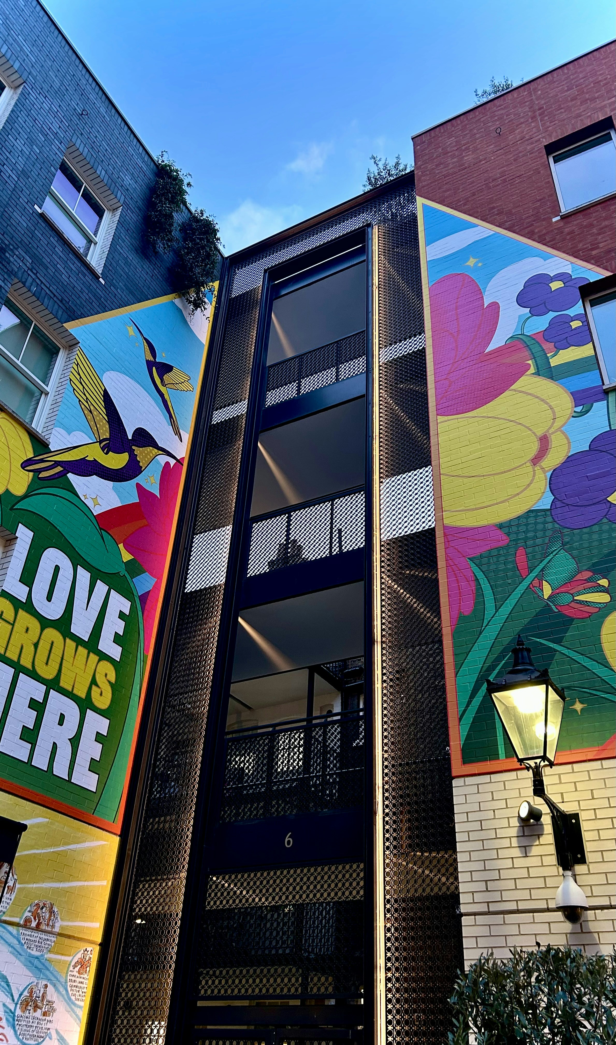 Colorful murals adorn buildings with a central walkway.