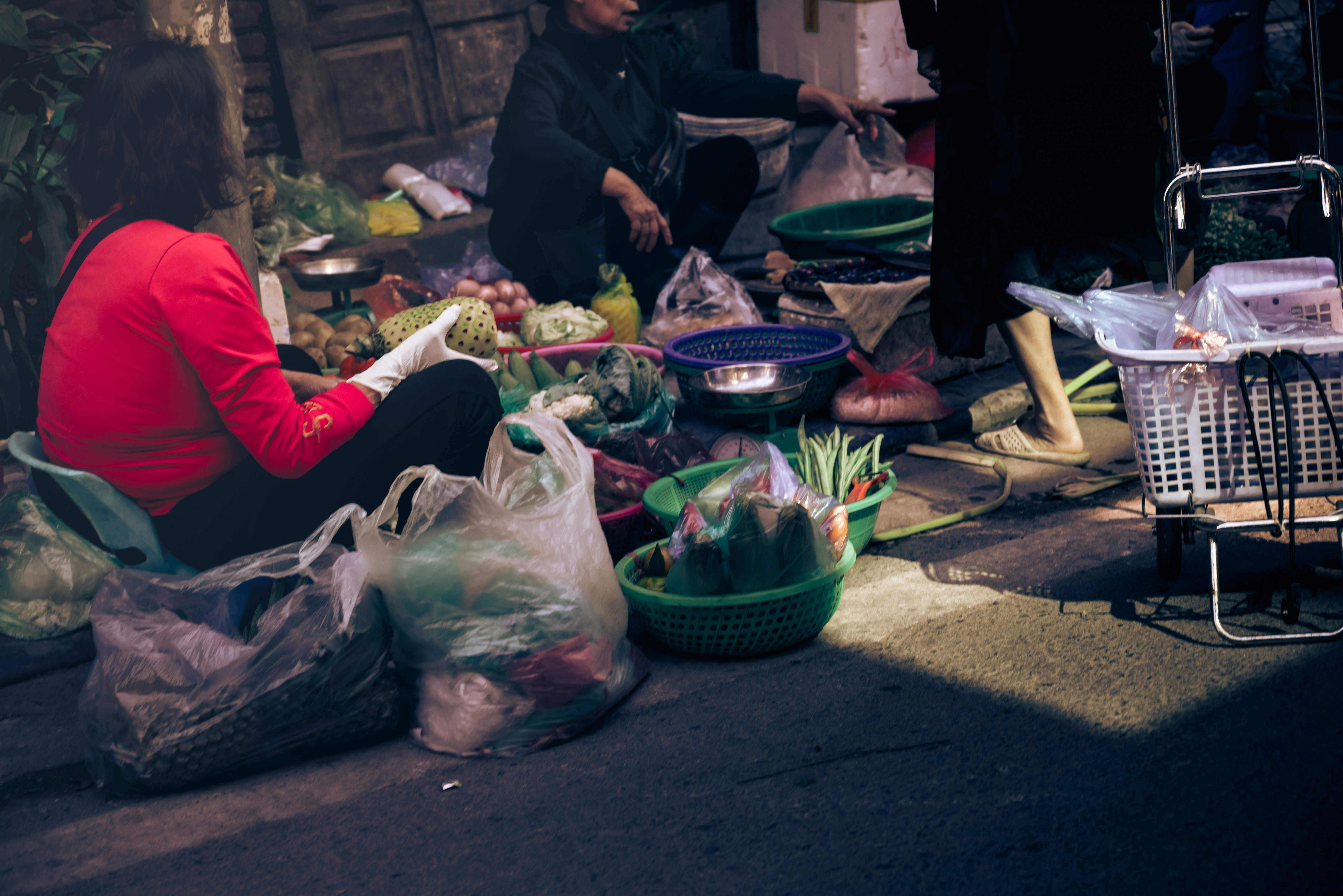 People selling produce at a street market.
