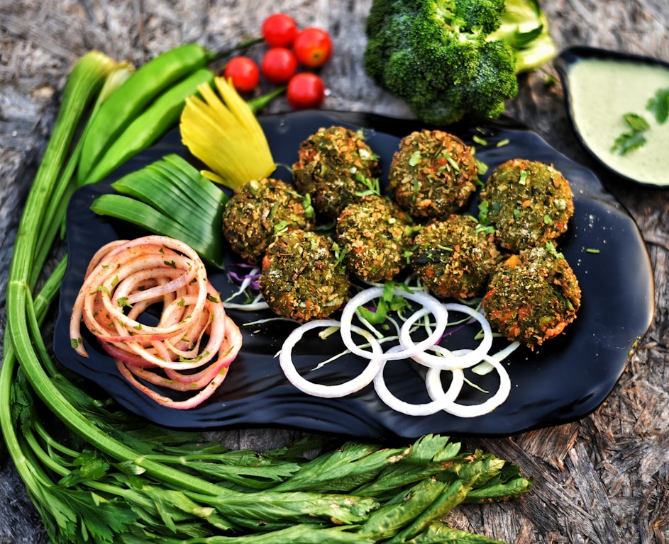 Golden crispy zucchini fritters served on a plate with onion and vegetables