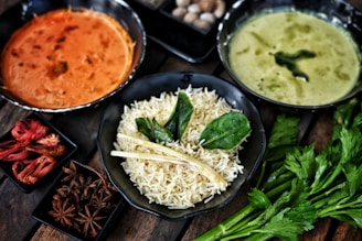 Three bowls of indian food with rice and spices