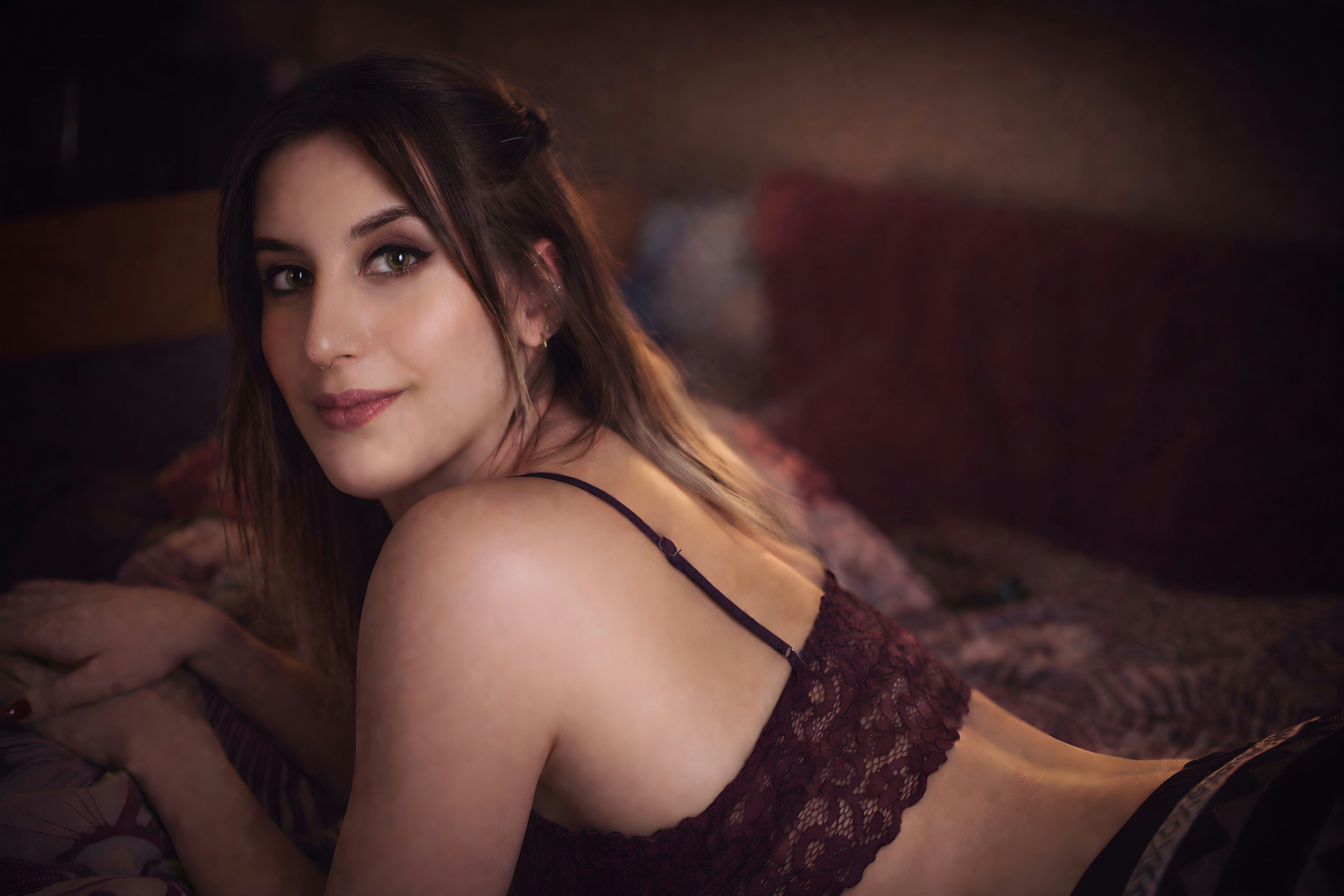 Joven tumbada en una cama, mirando a la cámara