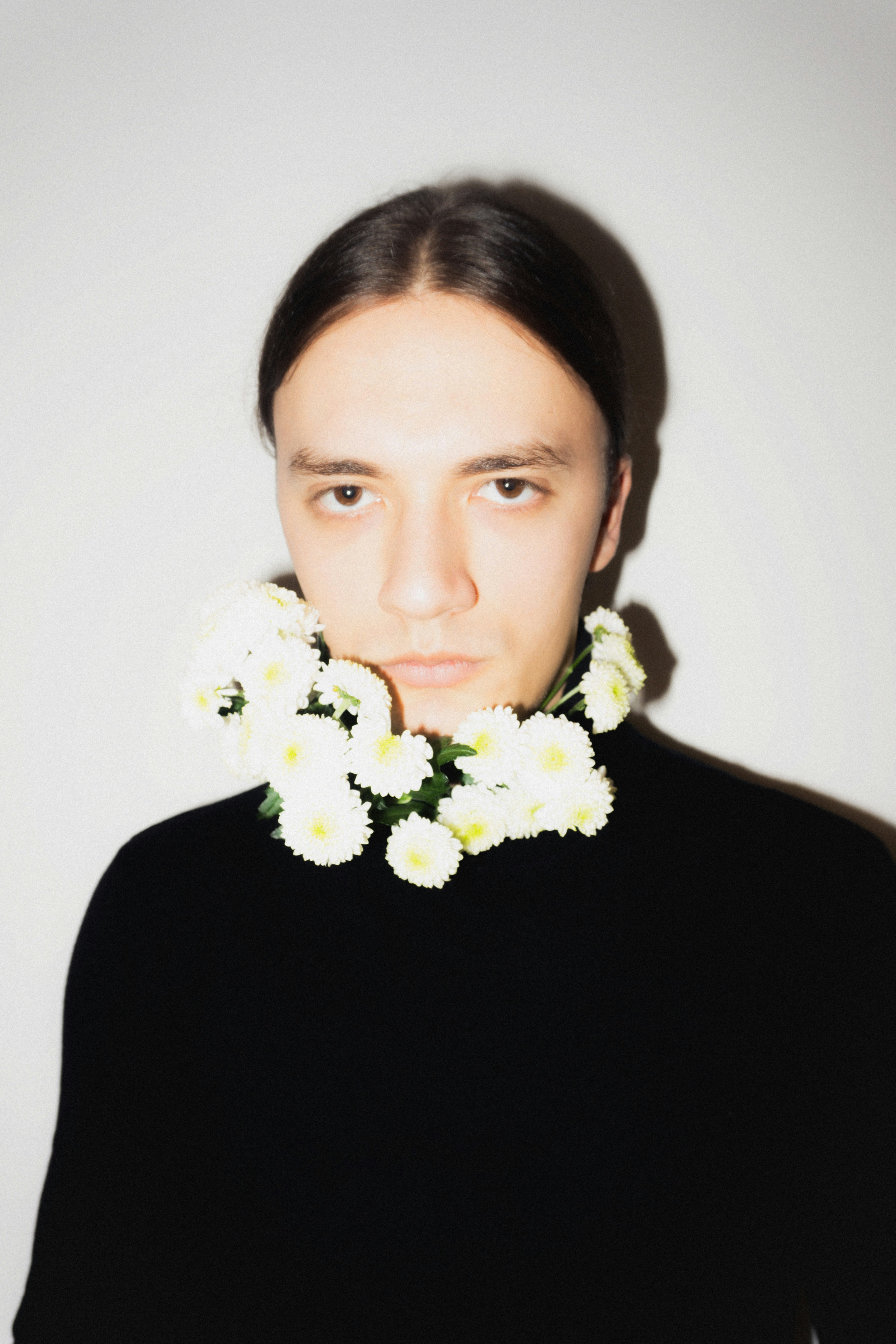 Man wearing a necklace of white flowers