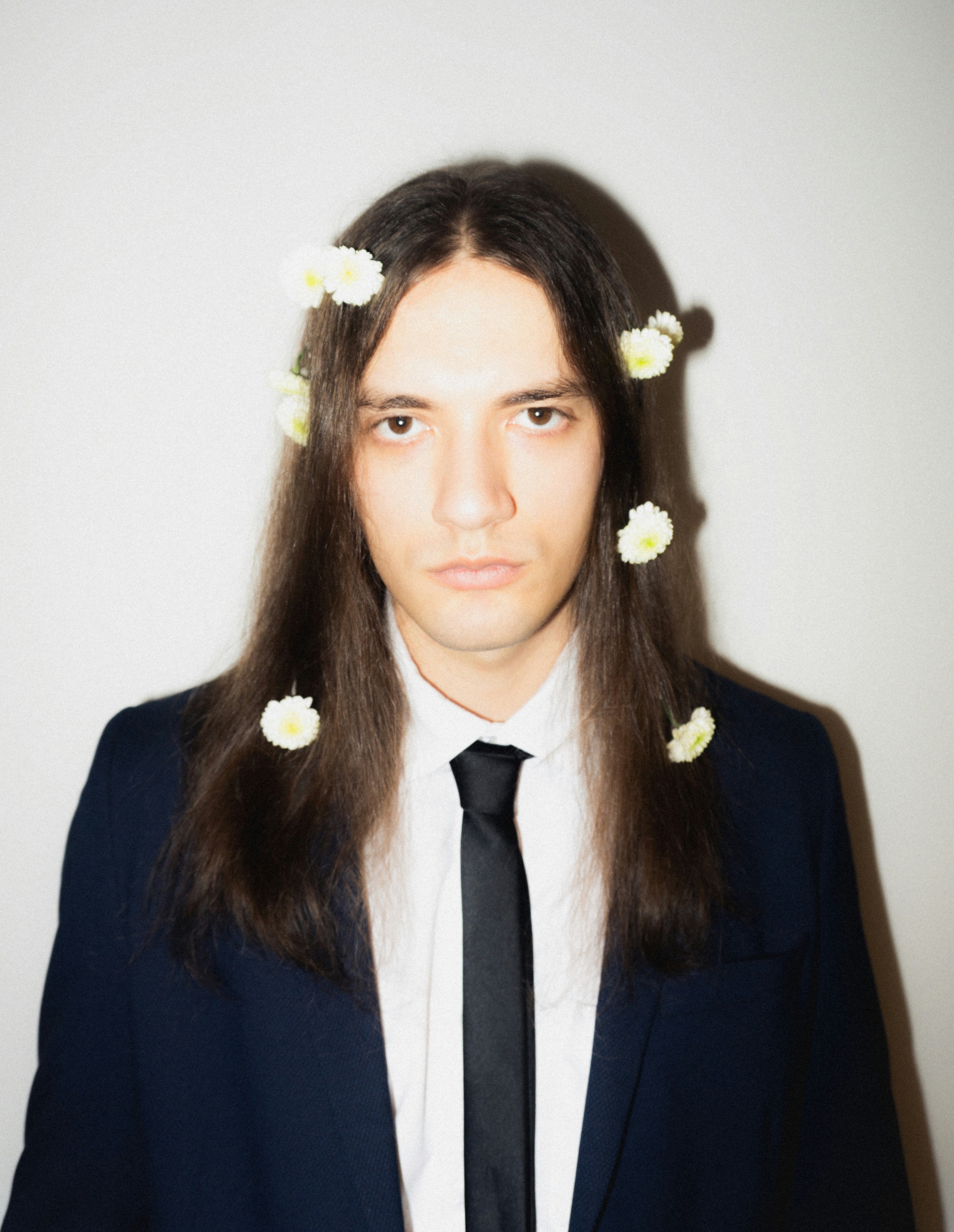 Man with long hair and flowers in suit
