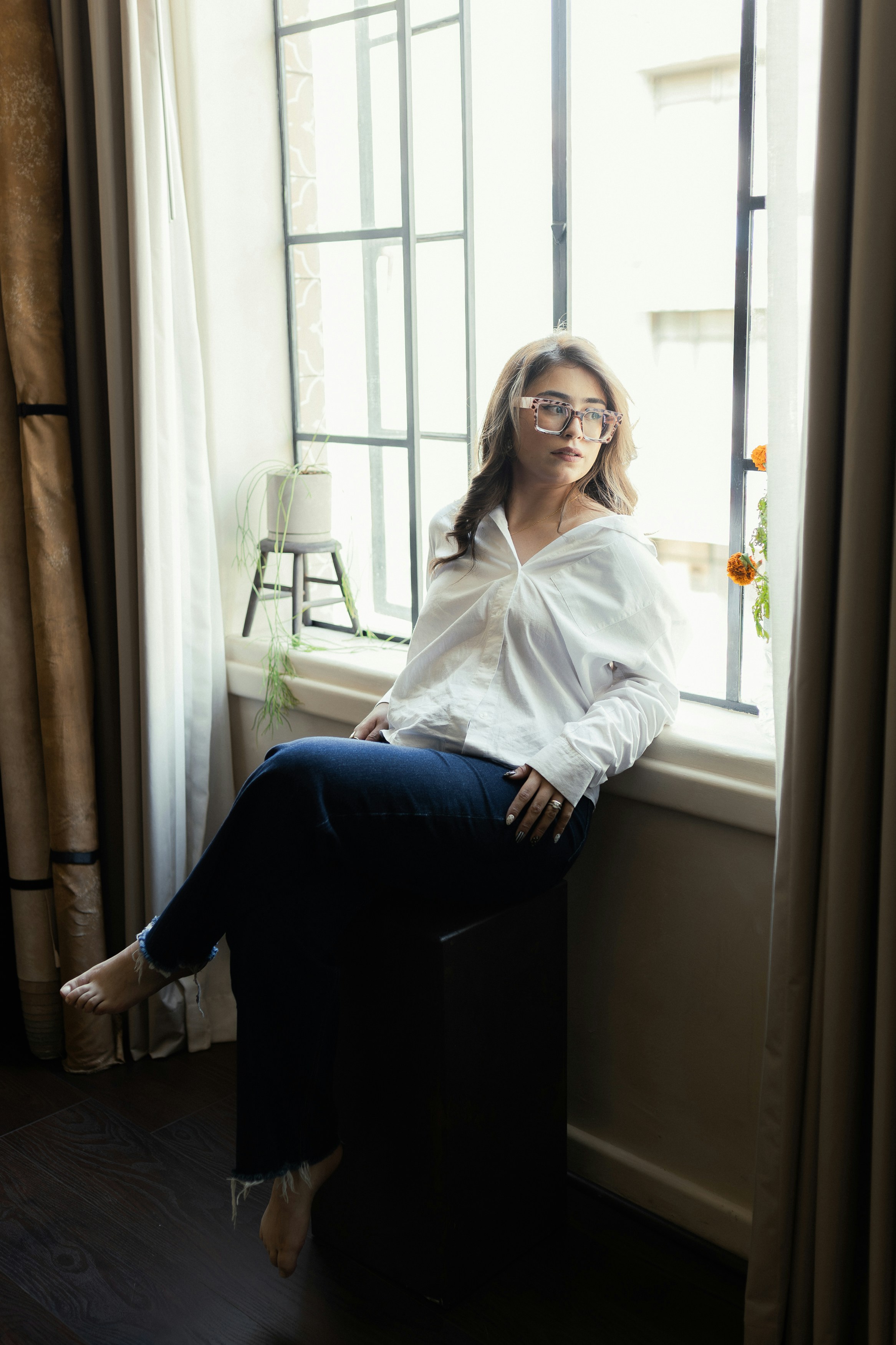 窓辺に座る白いシャツの女性