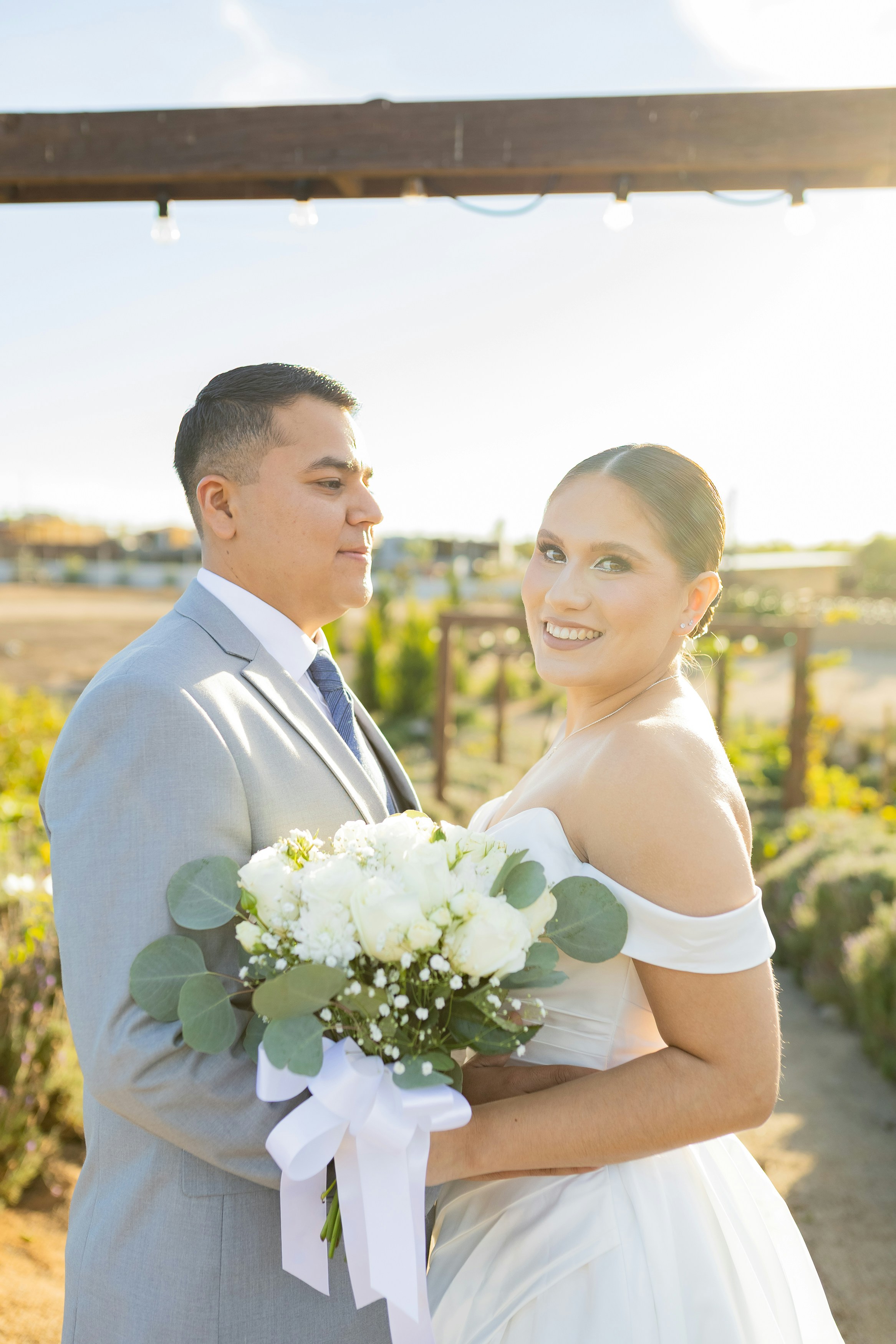 Bride and groom holding a white floral bouquet