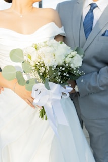 Bride and groom holding a white rose bouquet