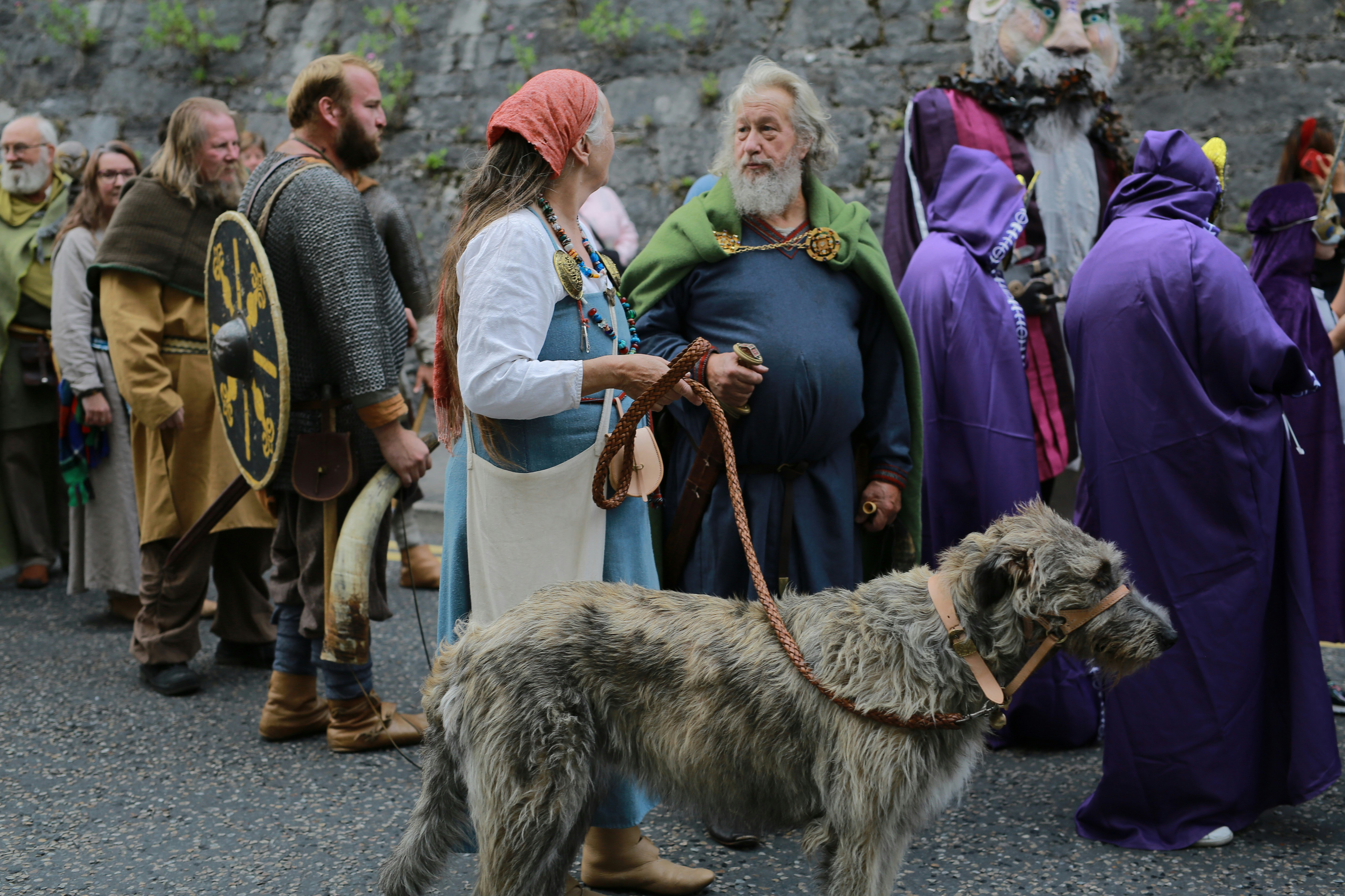 People in historical costumes with a large dog.