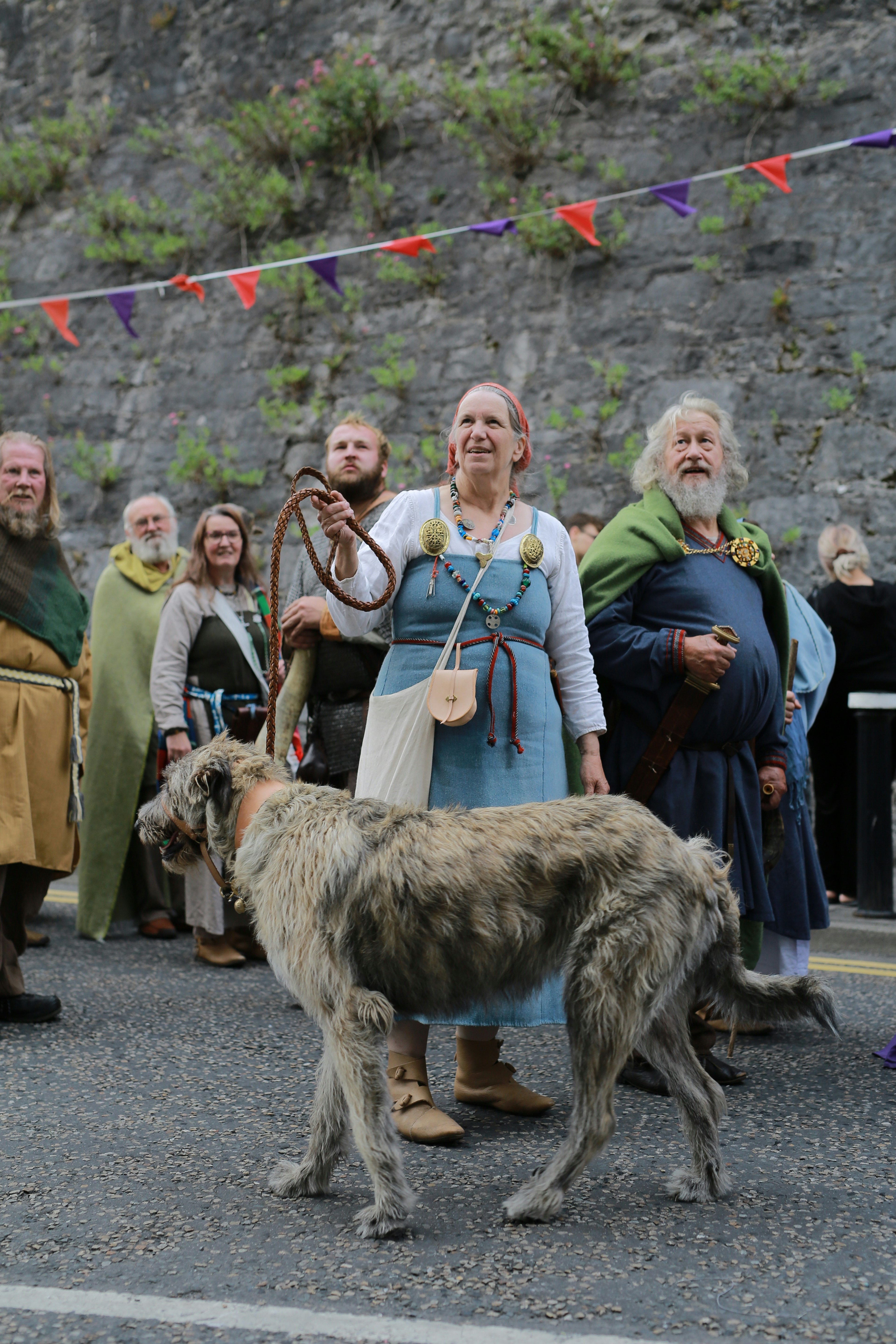 Mulher com cão lobo irlandês em evento de reencenação histórica