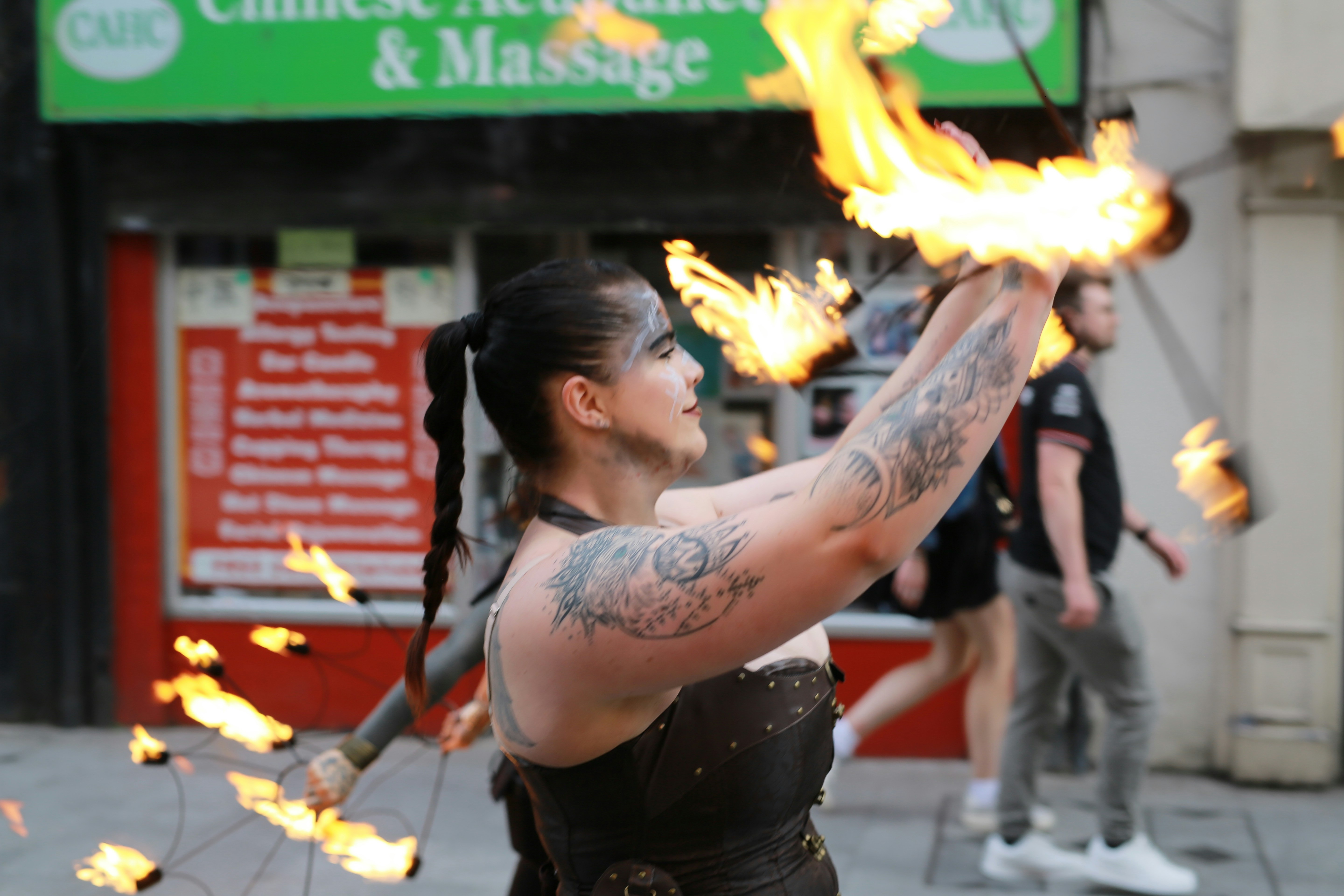 Woman performing with fire sticks at night
