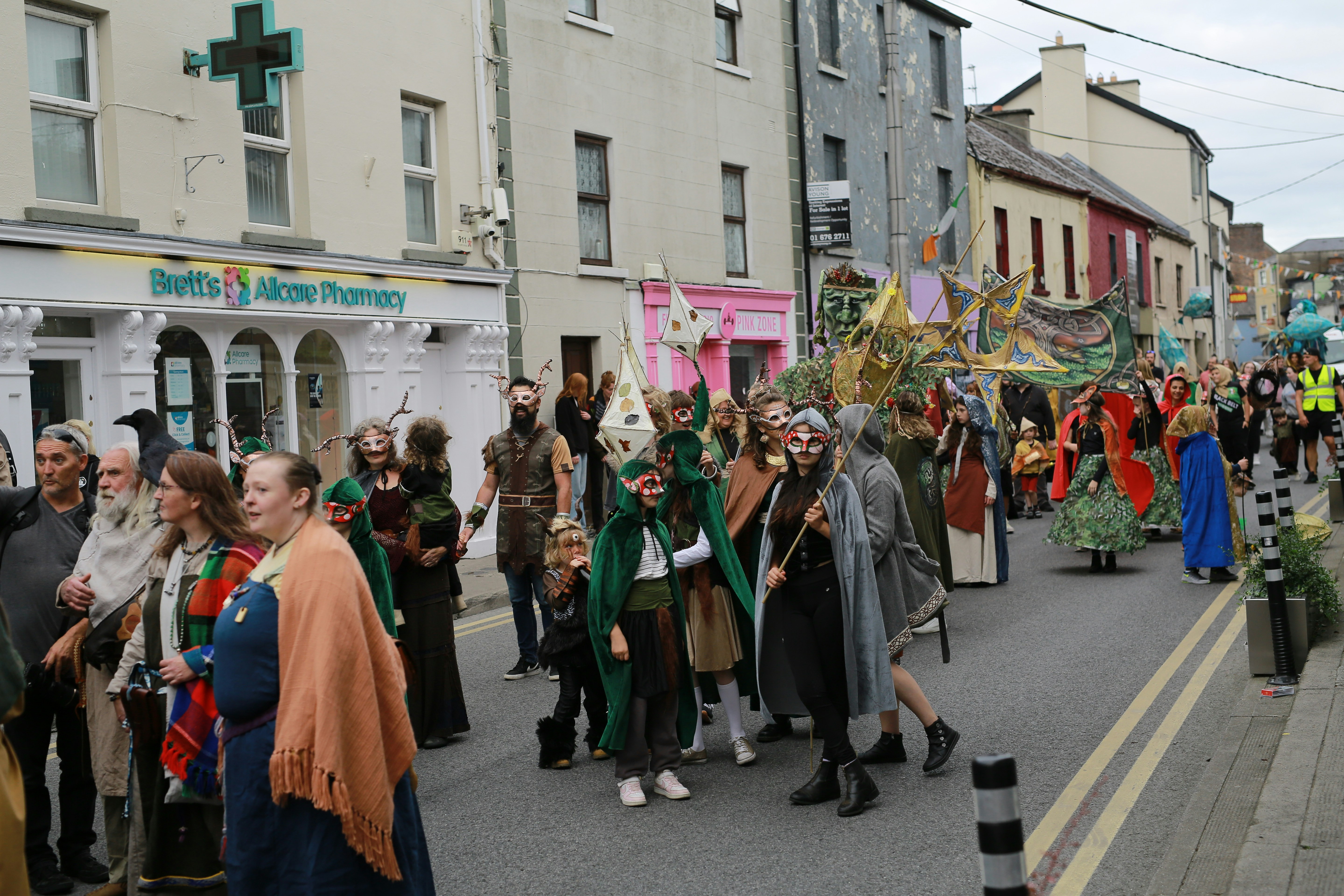 People in costumes marching down a street