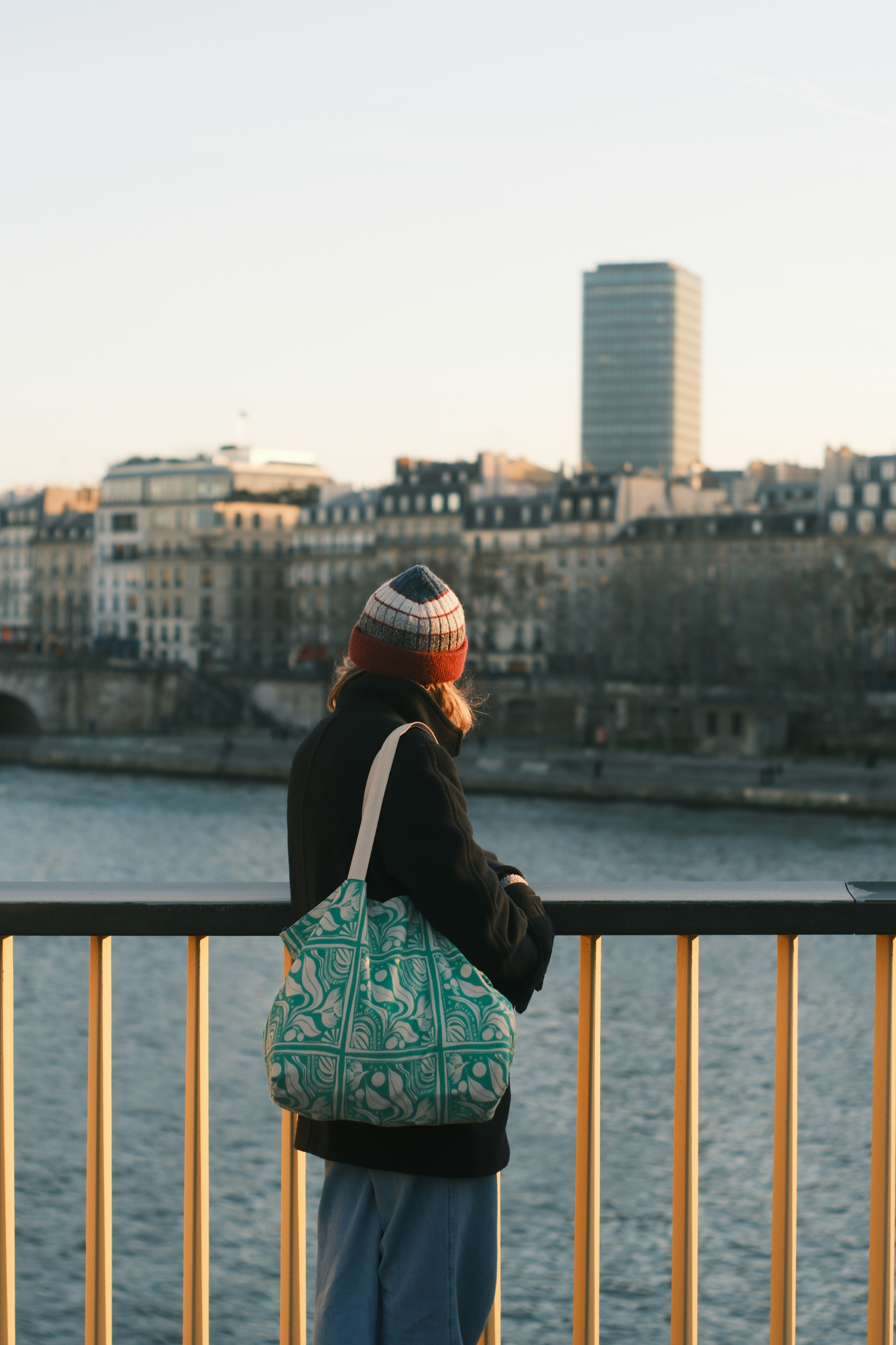 Woman with bag looks over city skyline
