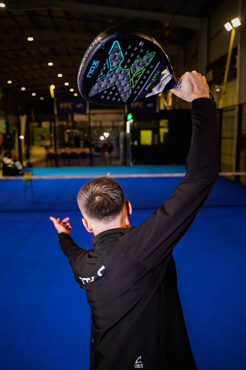 Padel player in long-sleeve kit on blue court