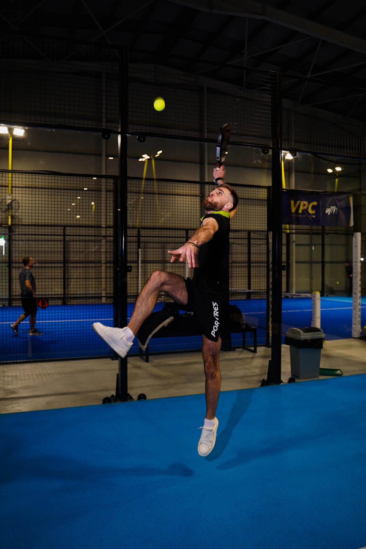 Joueur en pleine frappe sur court indoor