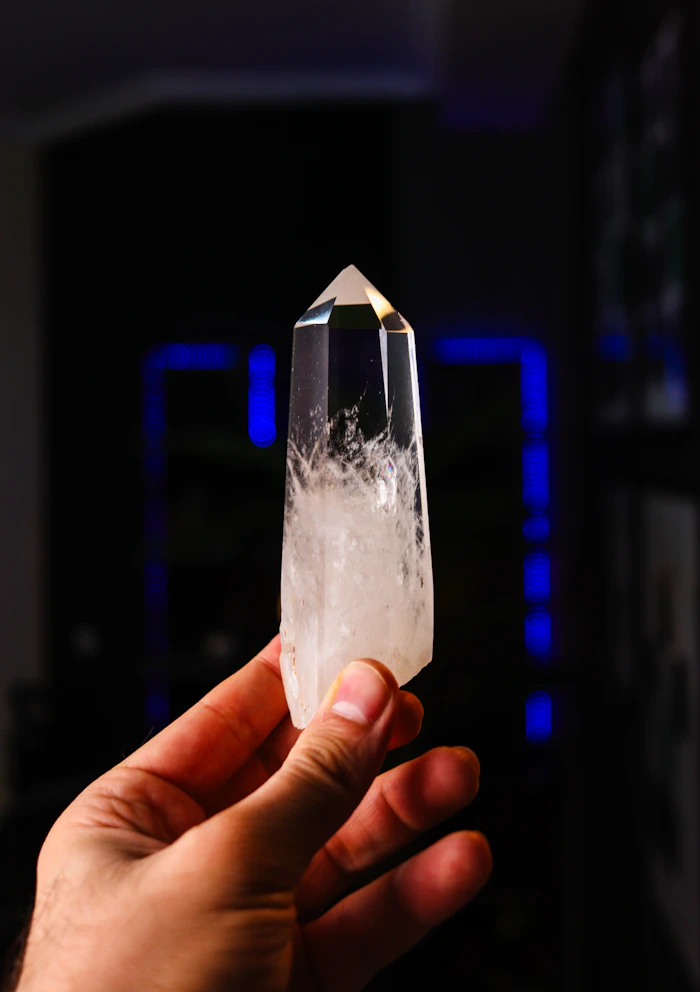 Hand holding a clear quartz crystal