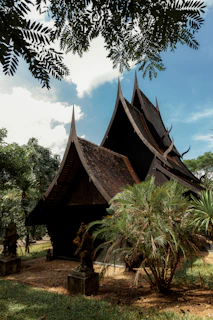 Dark traditional building surrounded by lush greenery