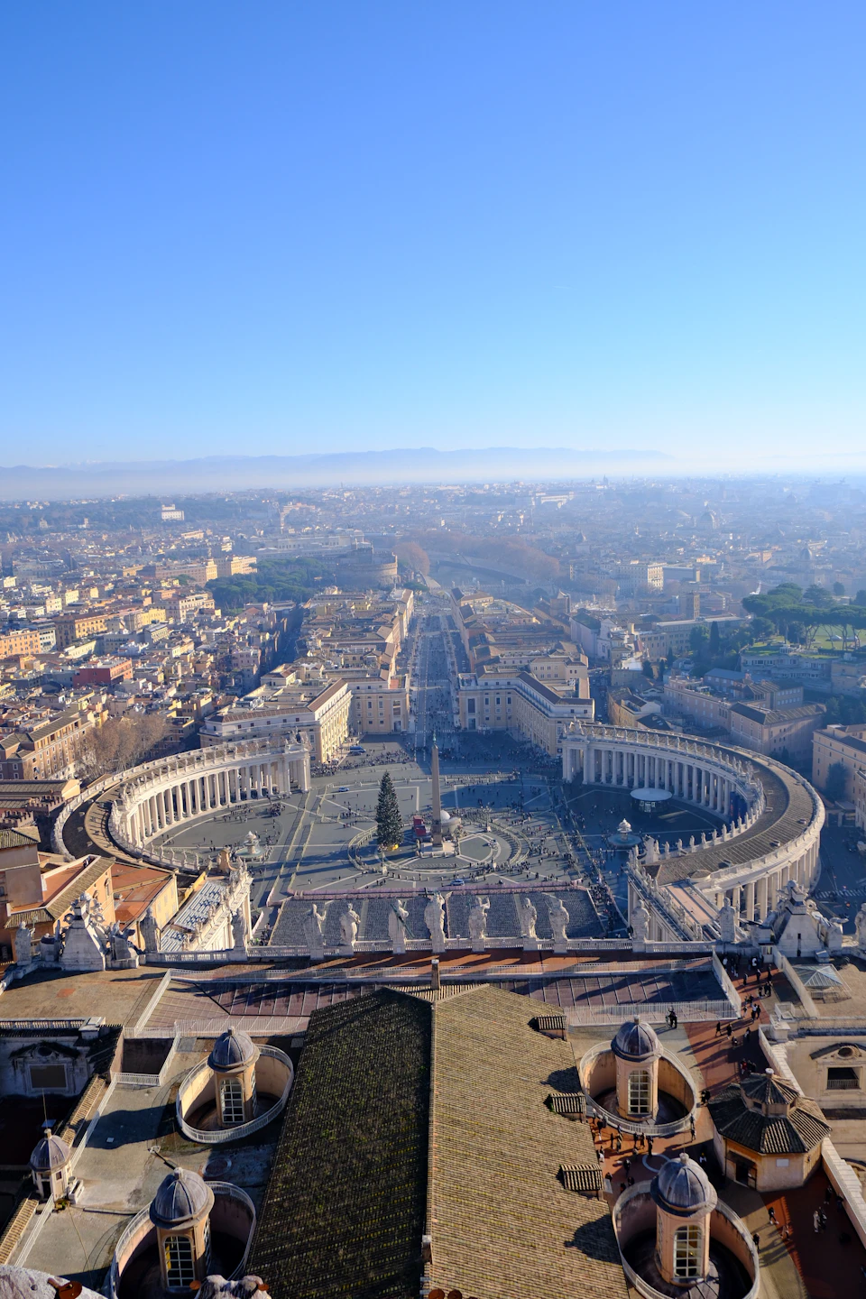 St Peter's Square Vatican with Christmas tree and basilica colonnades visible during the December holiday season