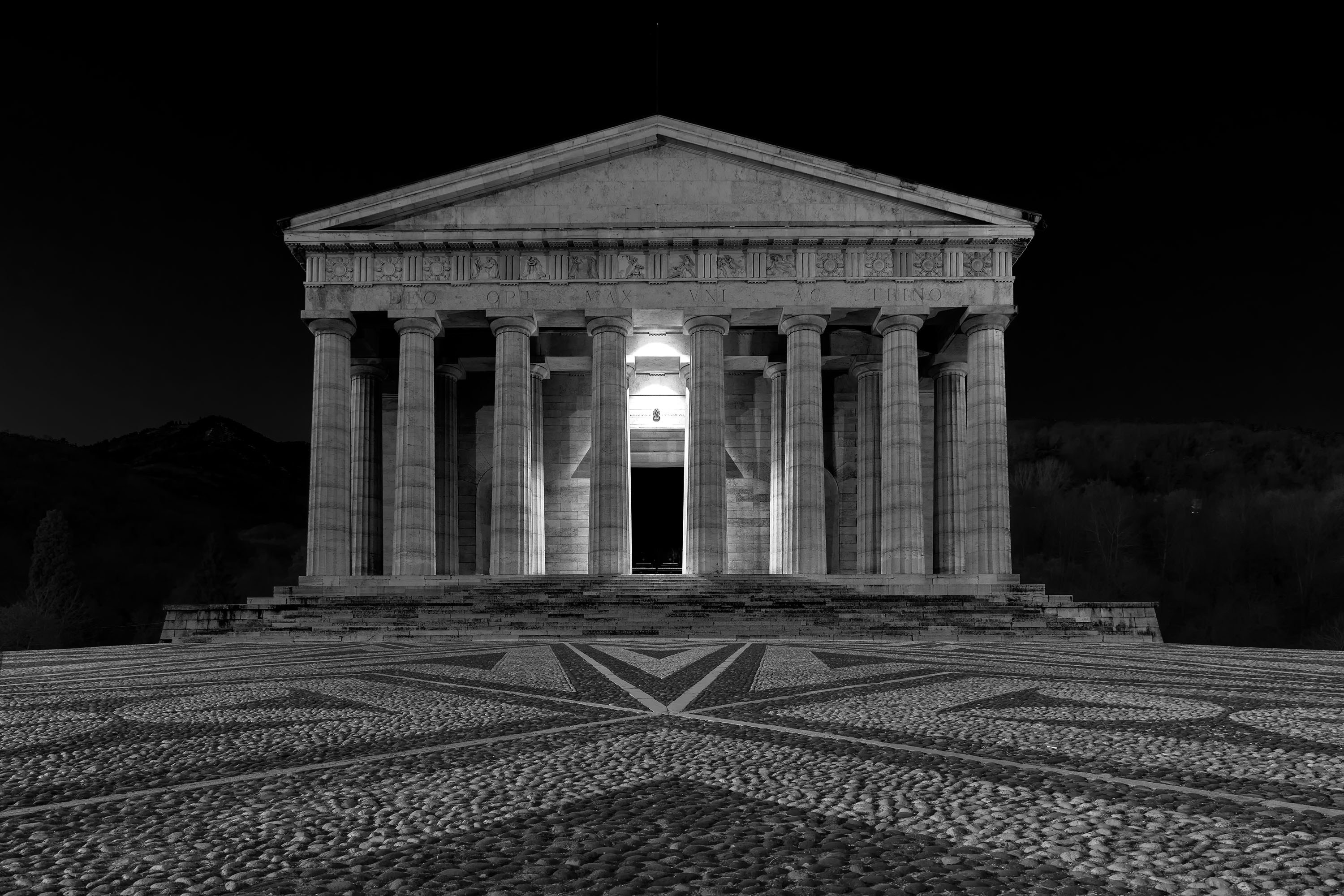 Antiker Tempel mit nachts beleuchteten Säulen.