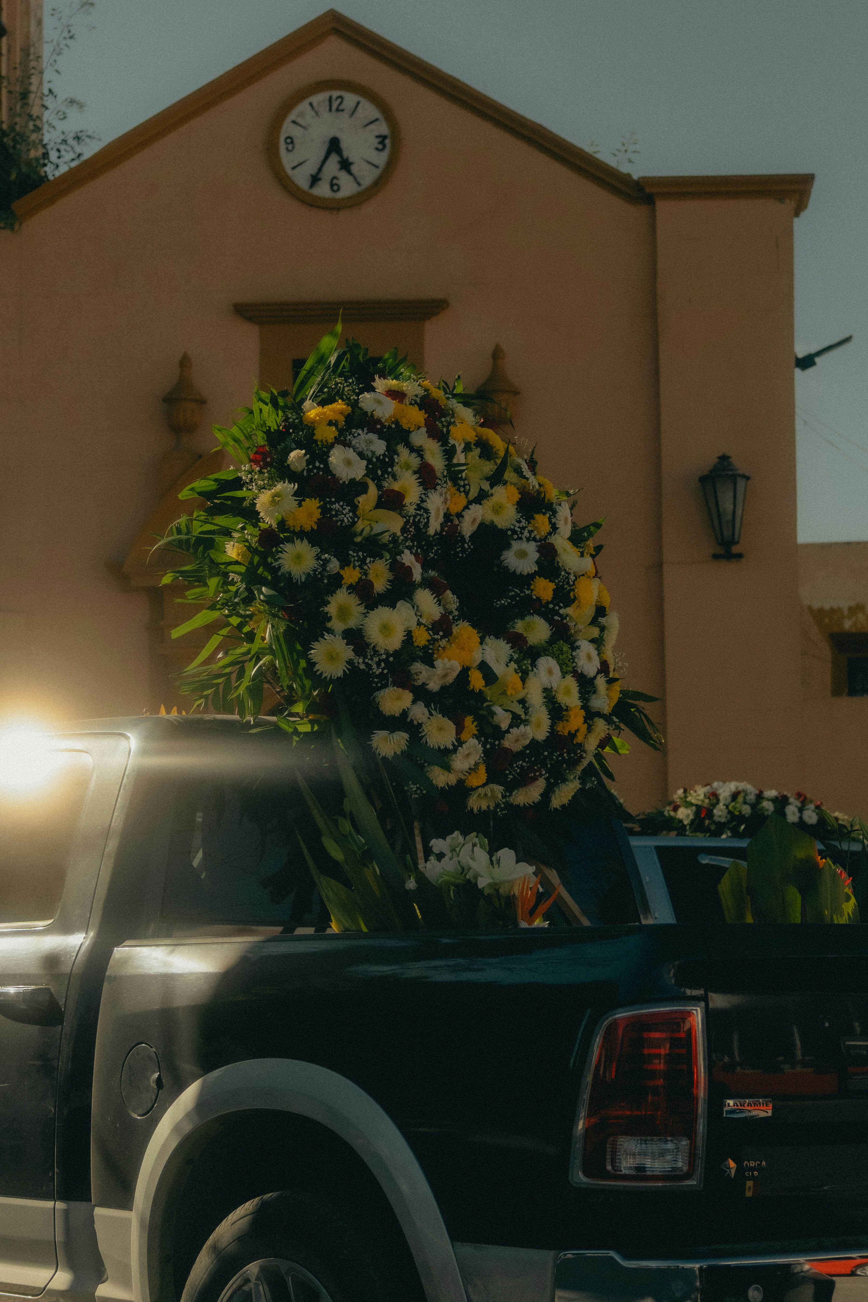 Large floral arrangement in truck bed with church background