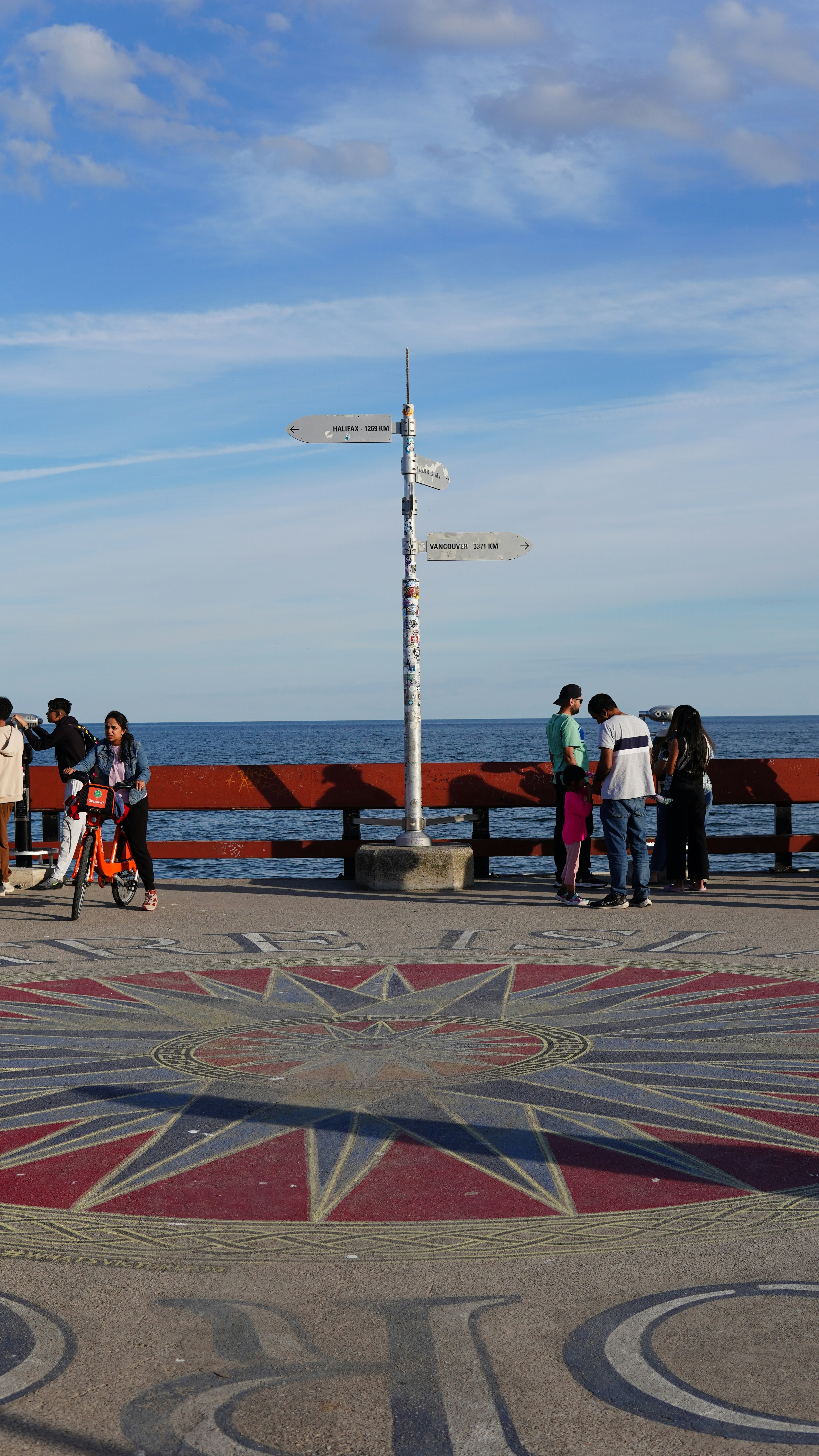 People on a pier with a compass rose design