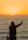 Fisherman casting line at sunrise over the ocean.