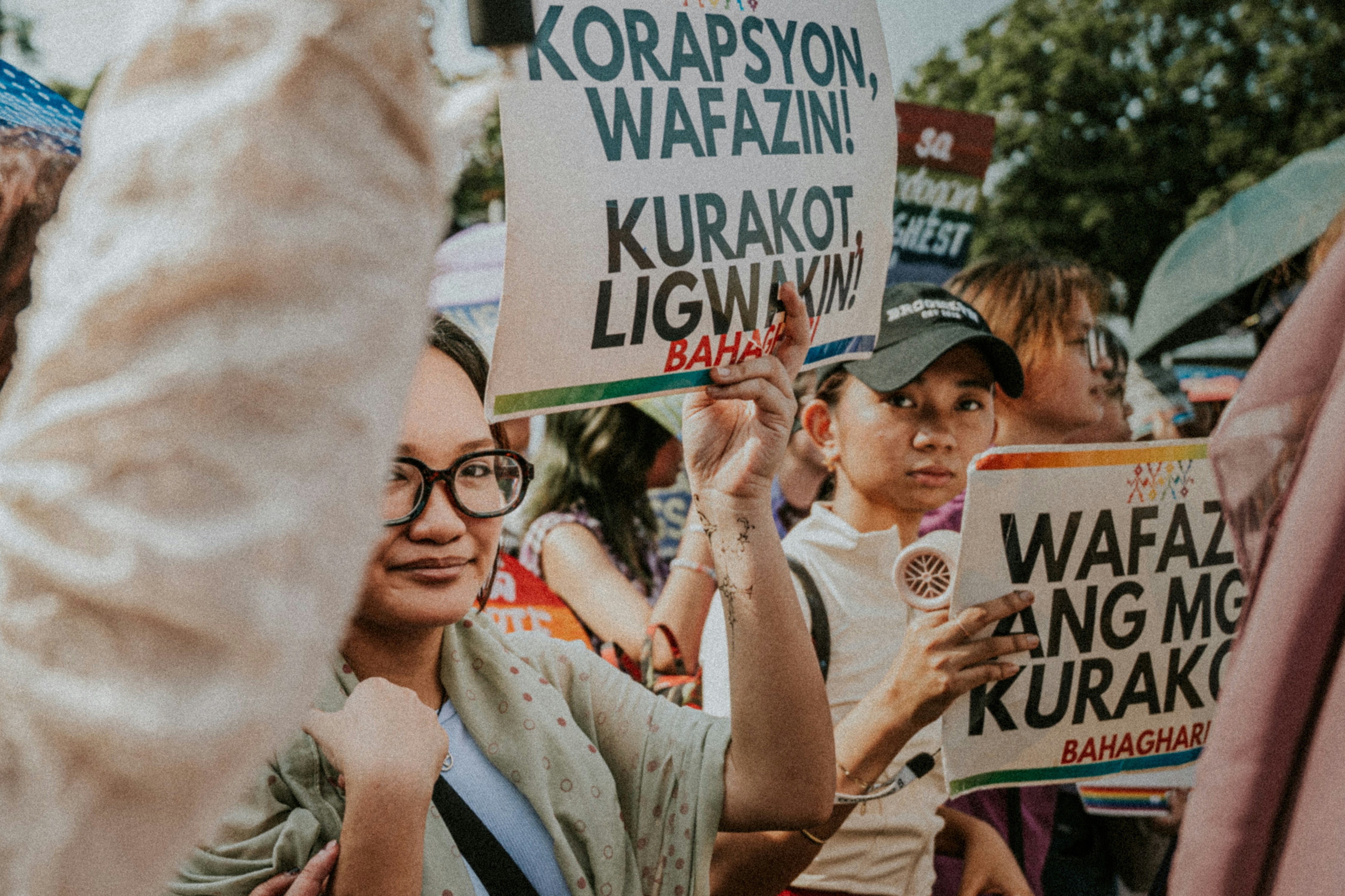 People holding protest signs at a rally.