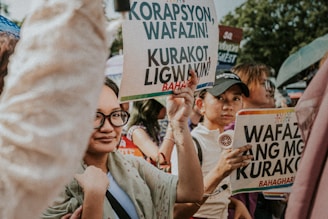 People holding protest signs at a rally.