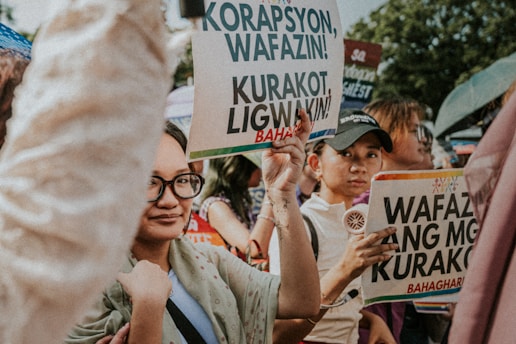 People holding protest signs at a rally.