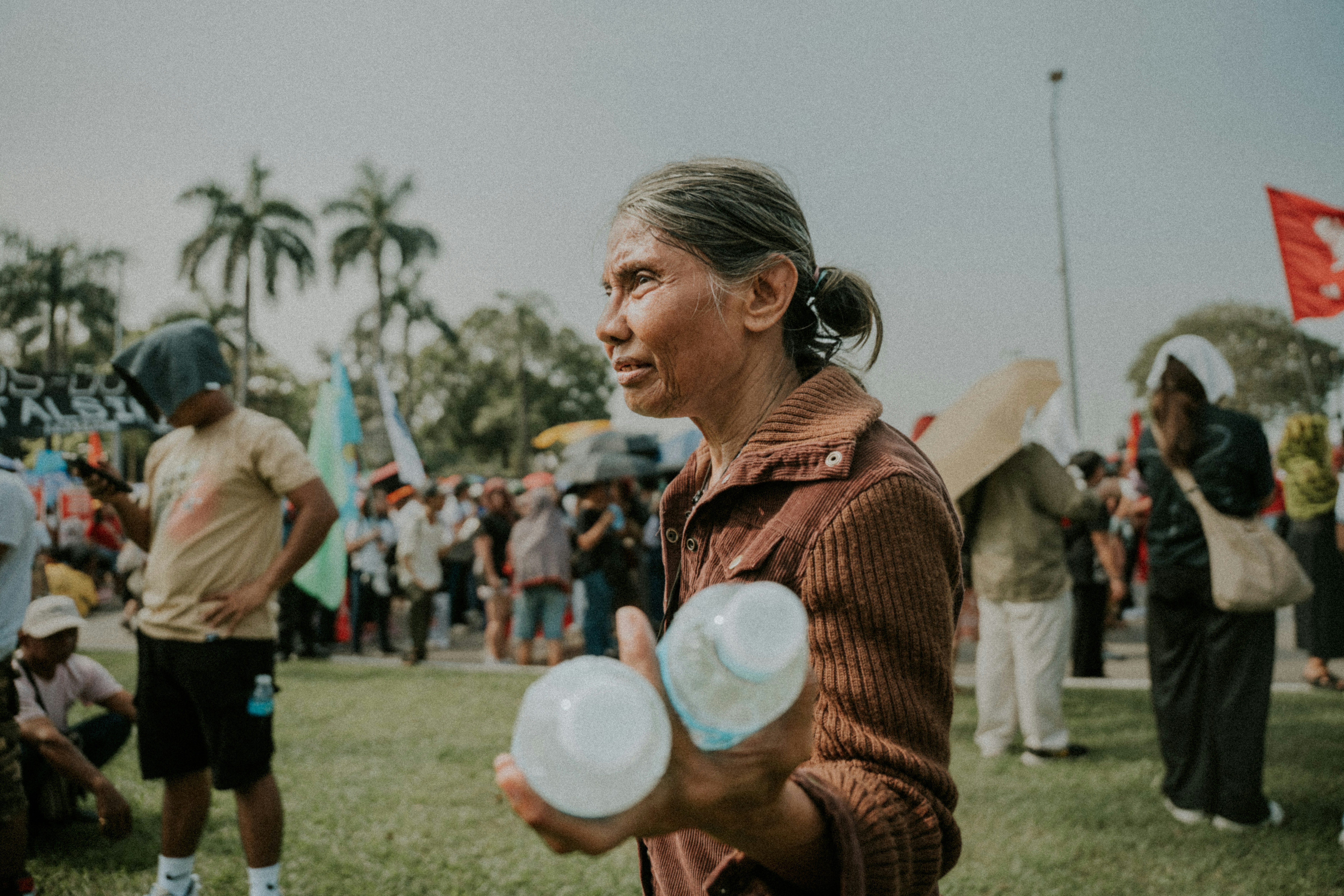 Woman holding two plastic containers outdoors