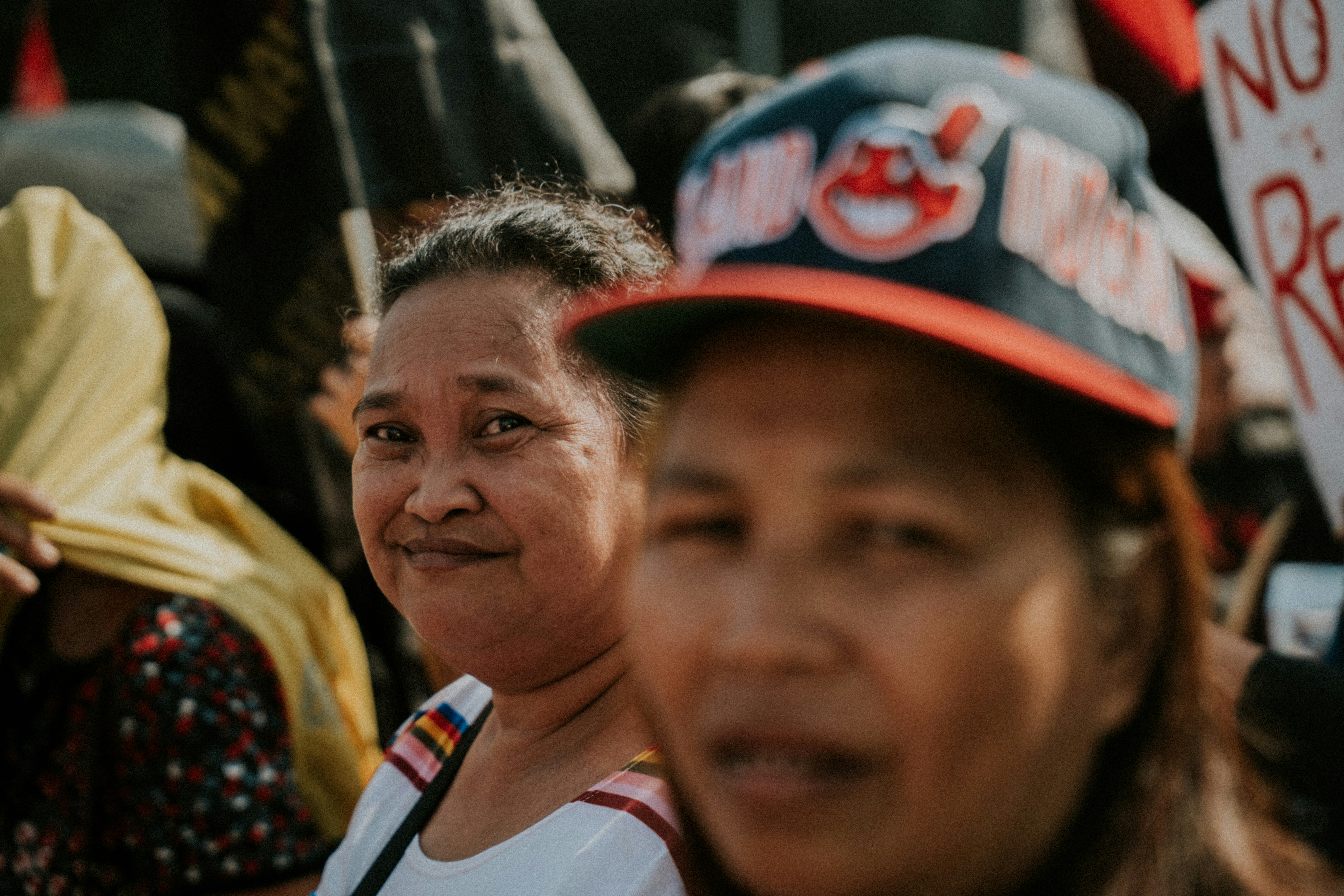Dos mujeres en una multitud en una reunión al aire libre.