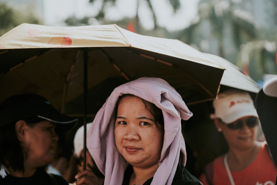 Woman with towel on head under umbrella