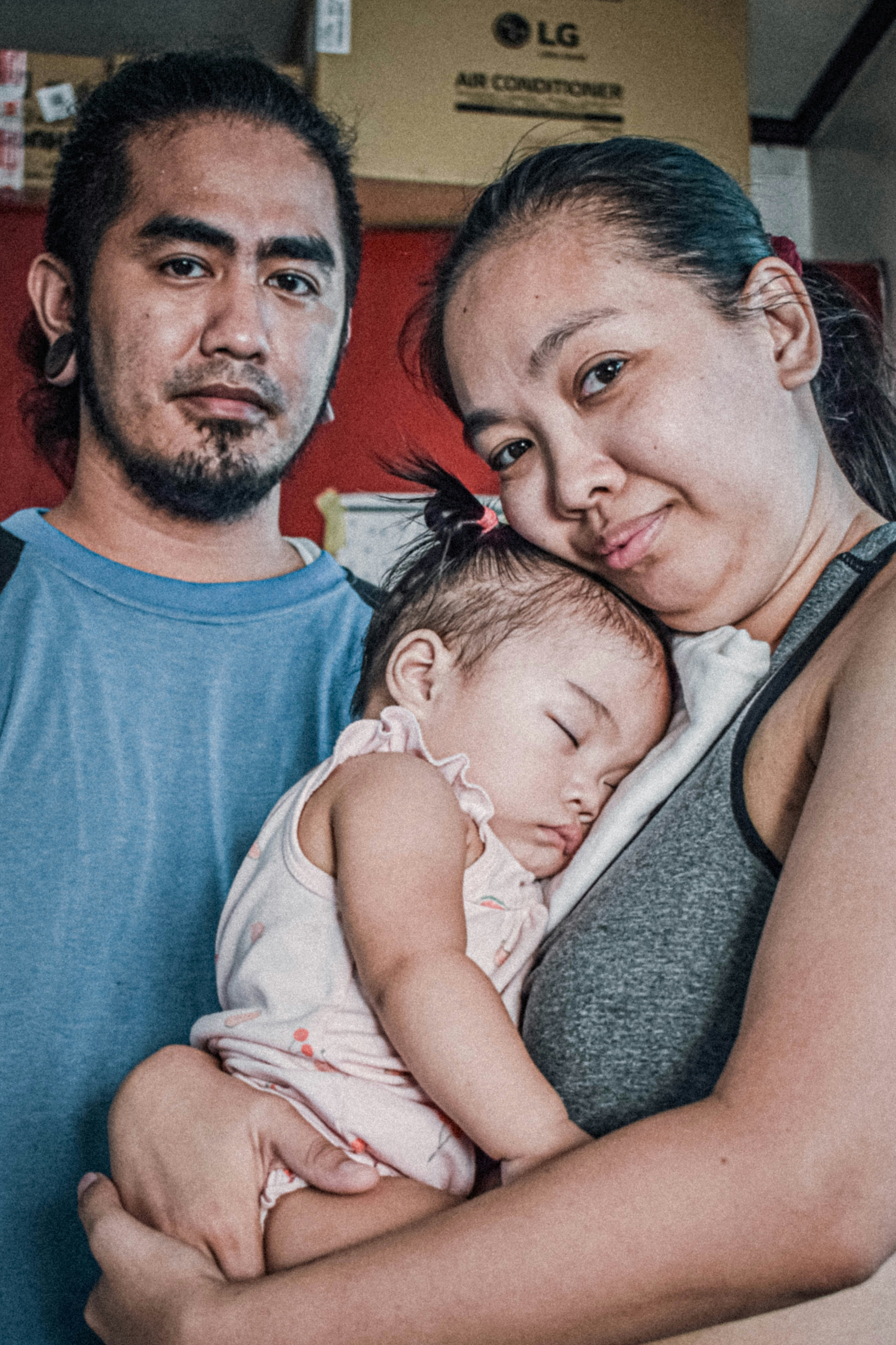 Padres sosteniendo a su hija dormida