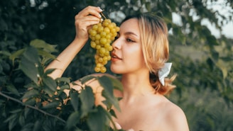 Woman holding a bunch of green grapes outdoors