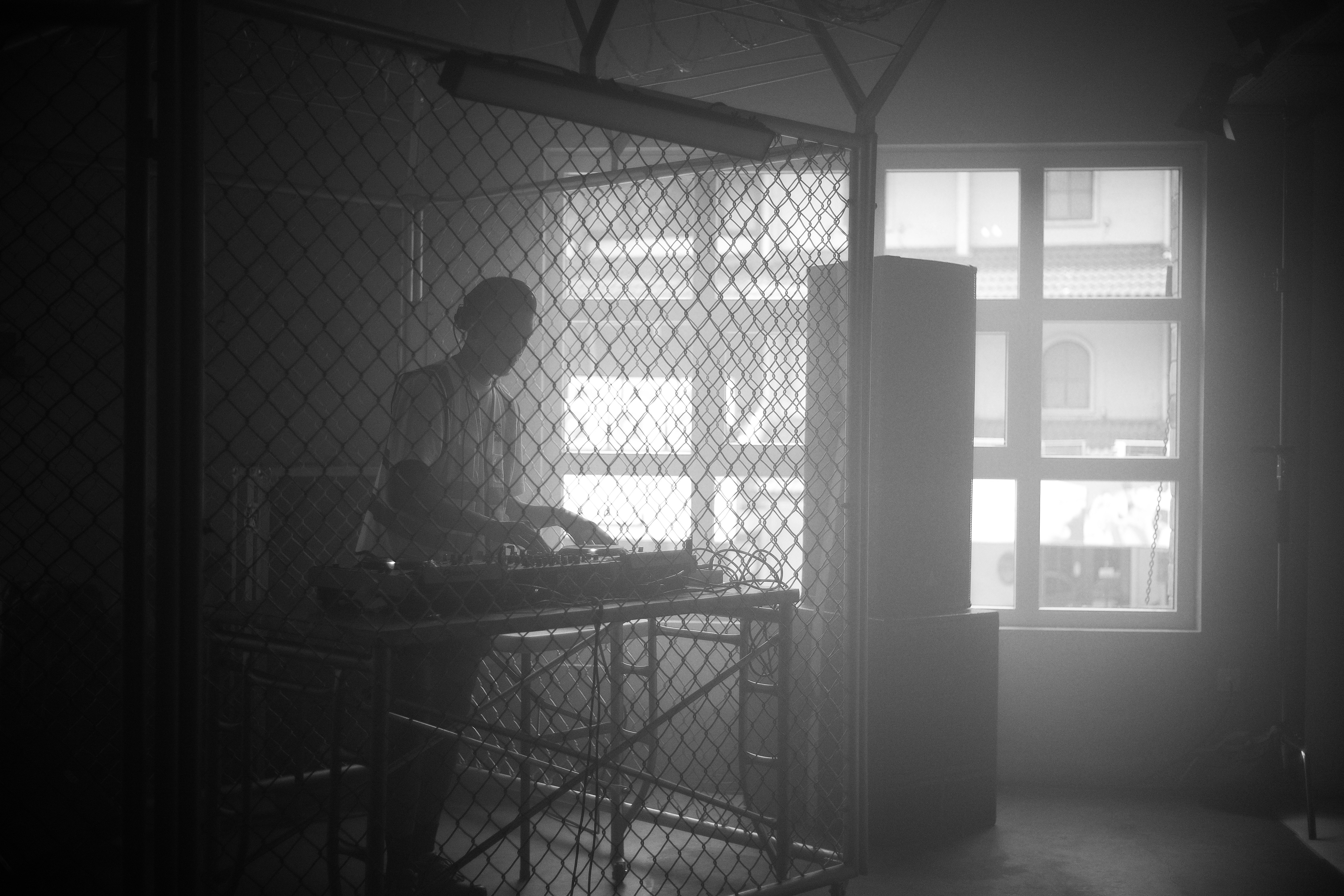 Man behind a fence with dj equipment