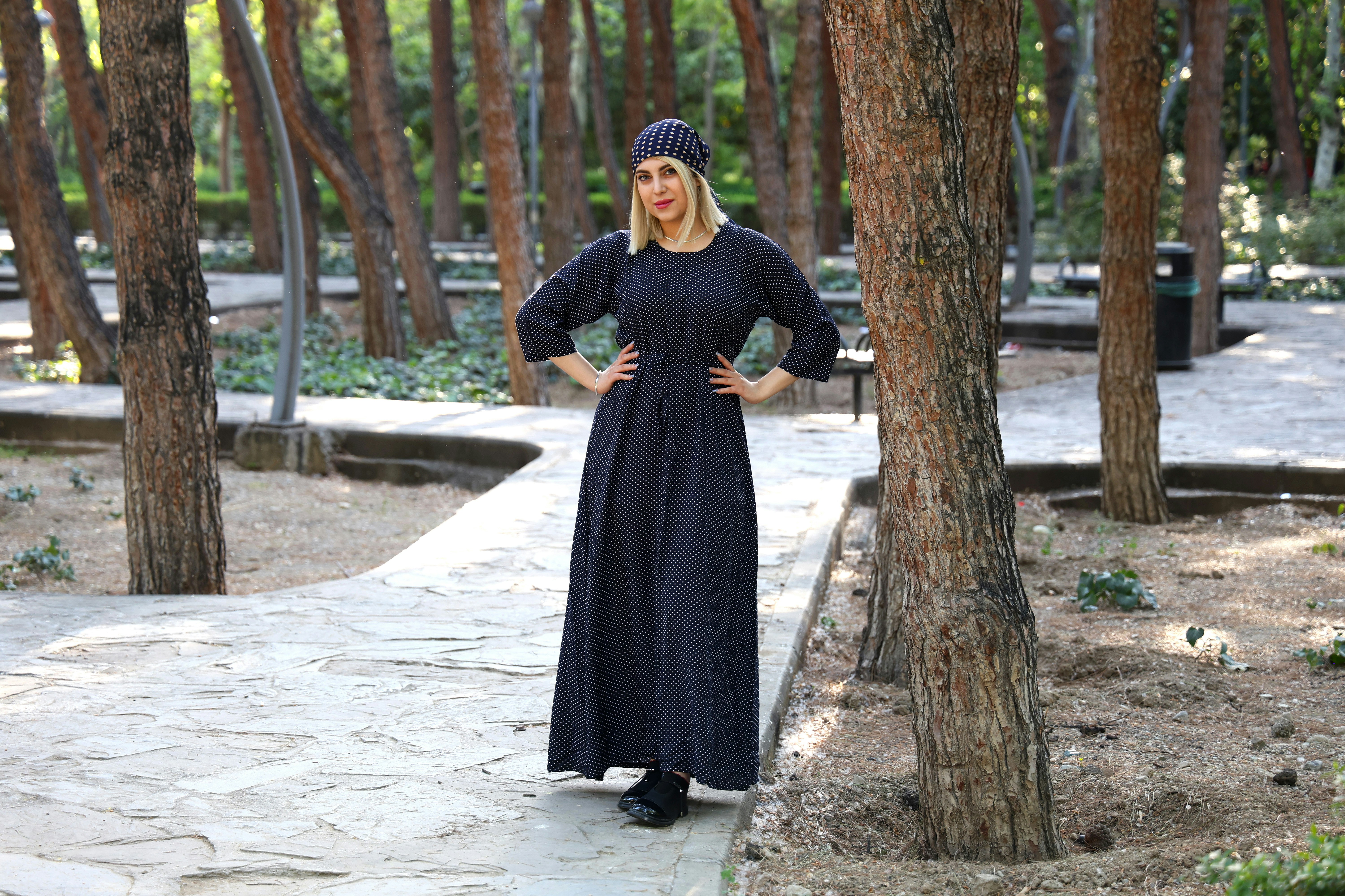 Woman wearing polka dot dress and headscarf in park - geometric pattern fashion
