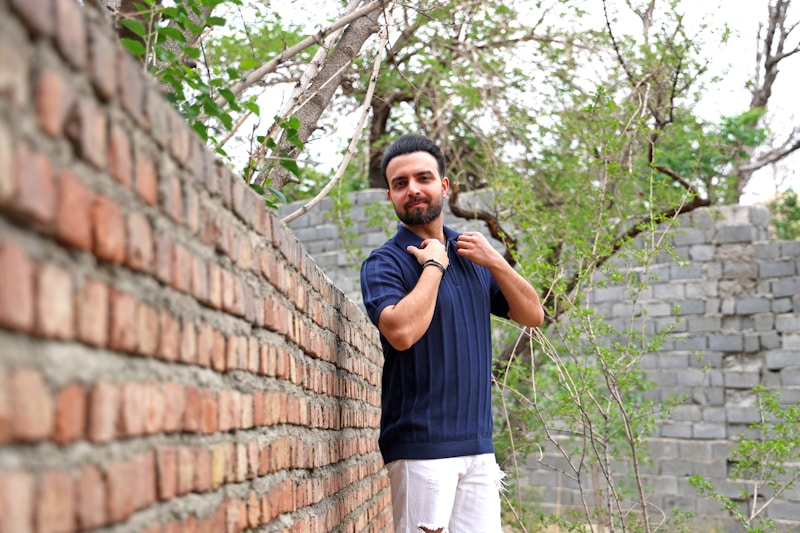 Man in dark blue shirt and white pants outdoors