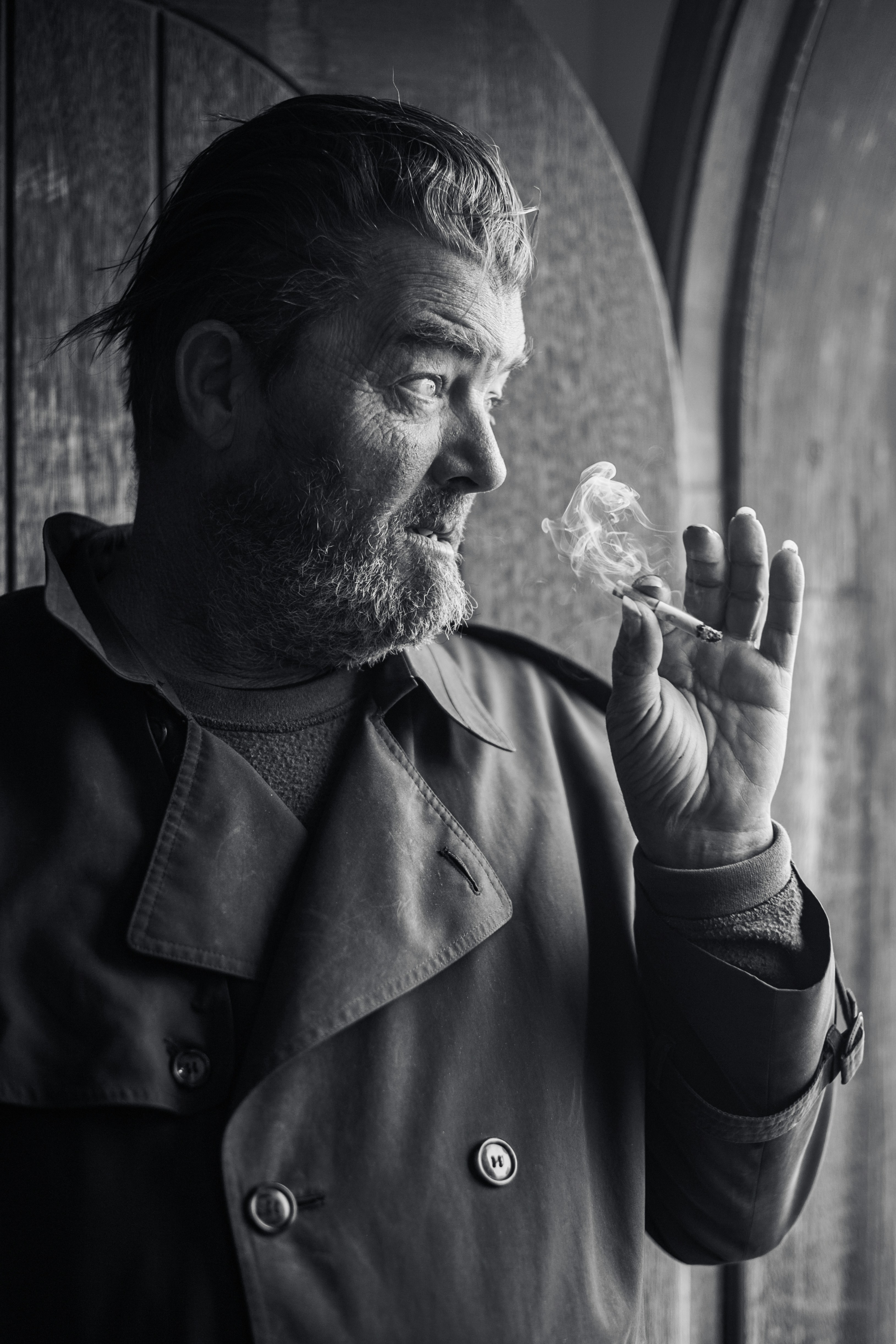 Uomo che fuma una sigaretta con il fumo che sale