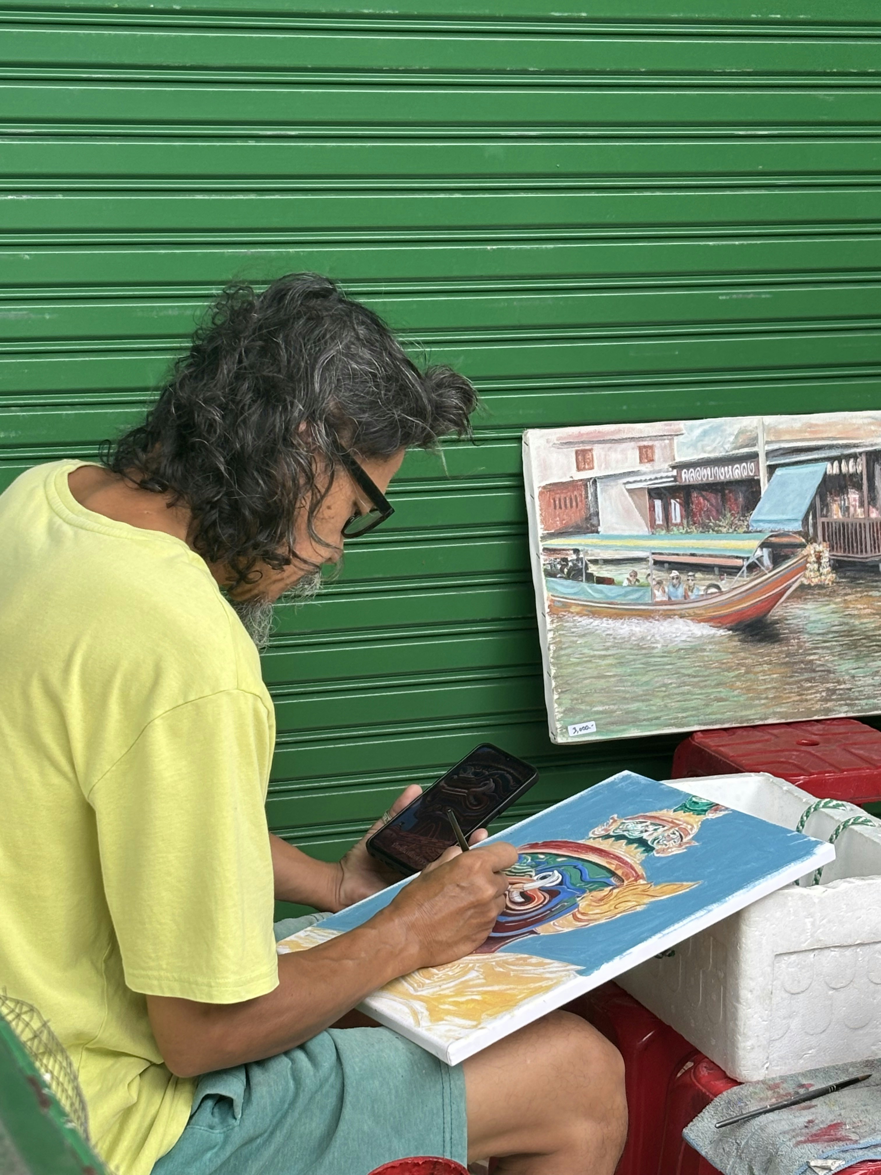 Man painting a colorful artwork with a phone