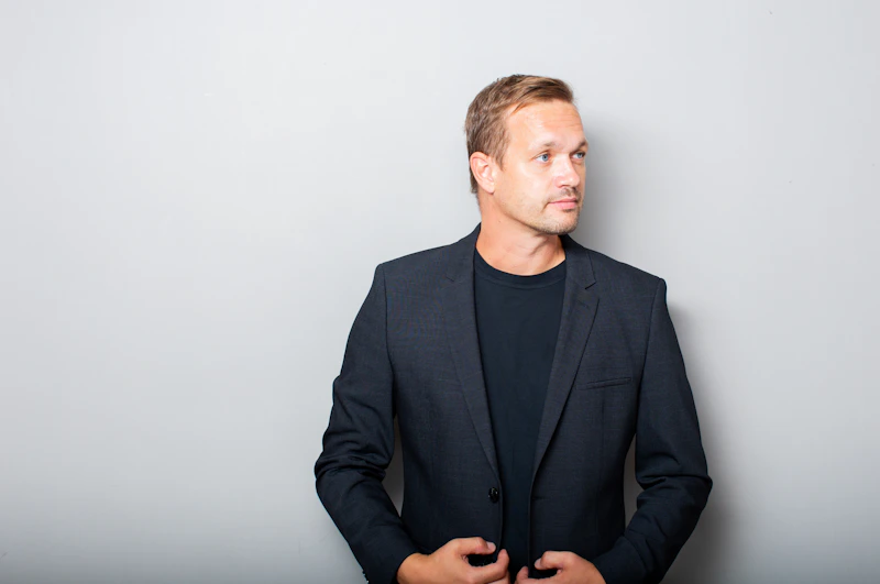 一位身穿深色西装外套和衬衫的男士，尽显绅士风范