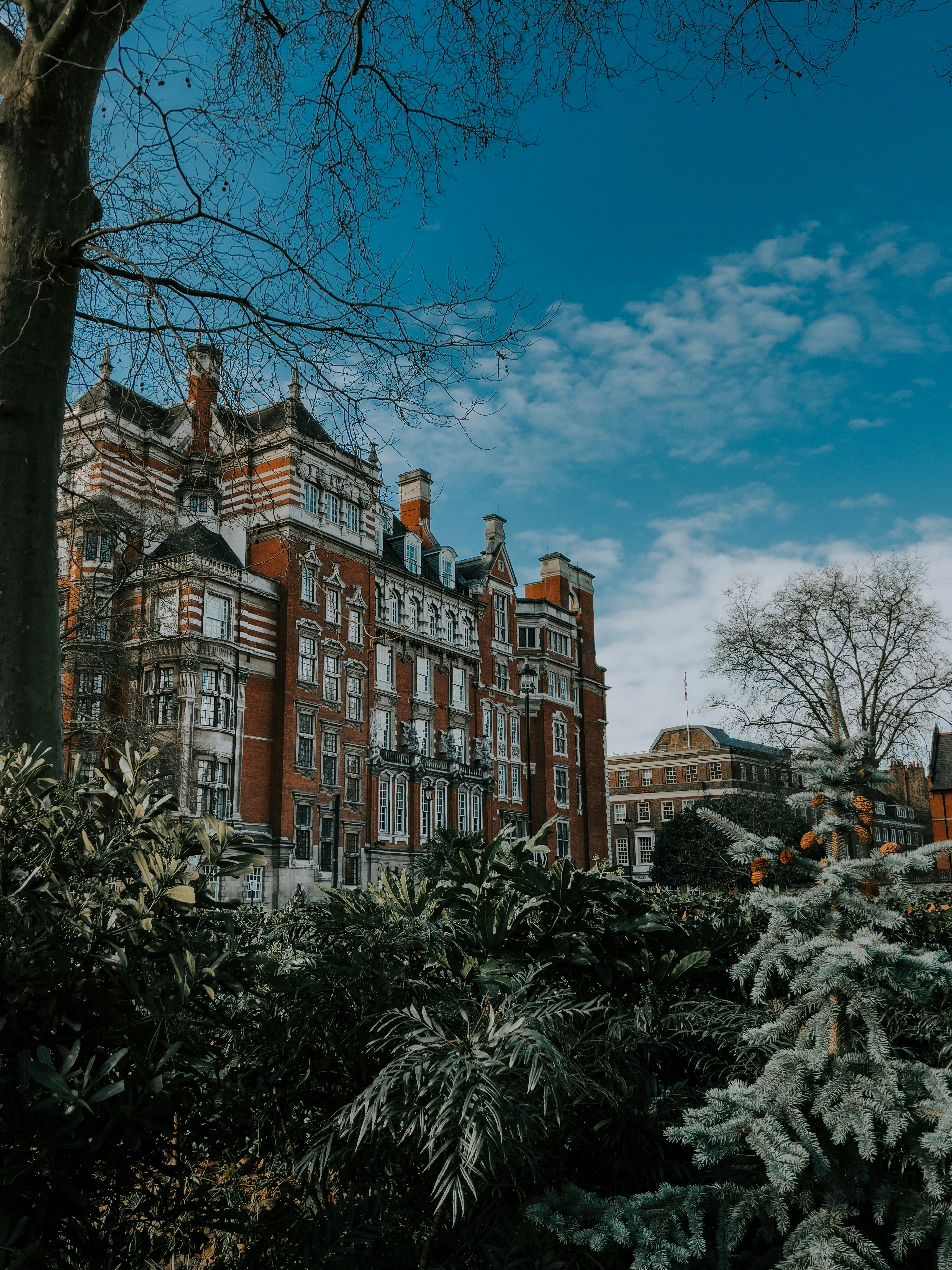 Großes Backsteingebäude mit kunstvollen architektonischen Details unter blauem Himmel.