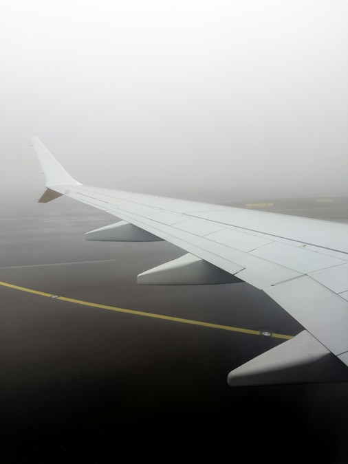Aile d’avion au-dessus d’un tarmac noyé dans le brouillard, à l’approche du programme d’hiver 2026 de Ryanair à Charleroi