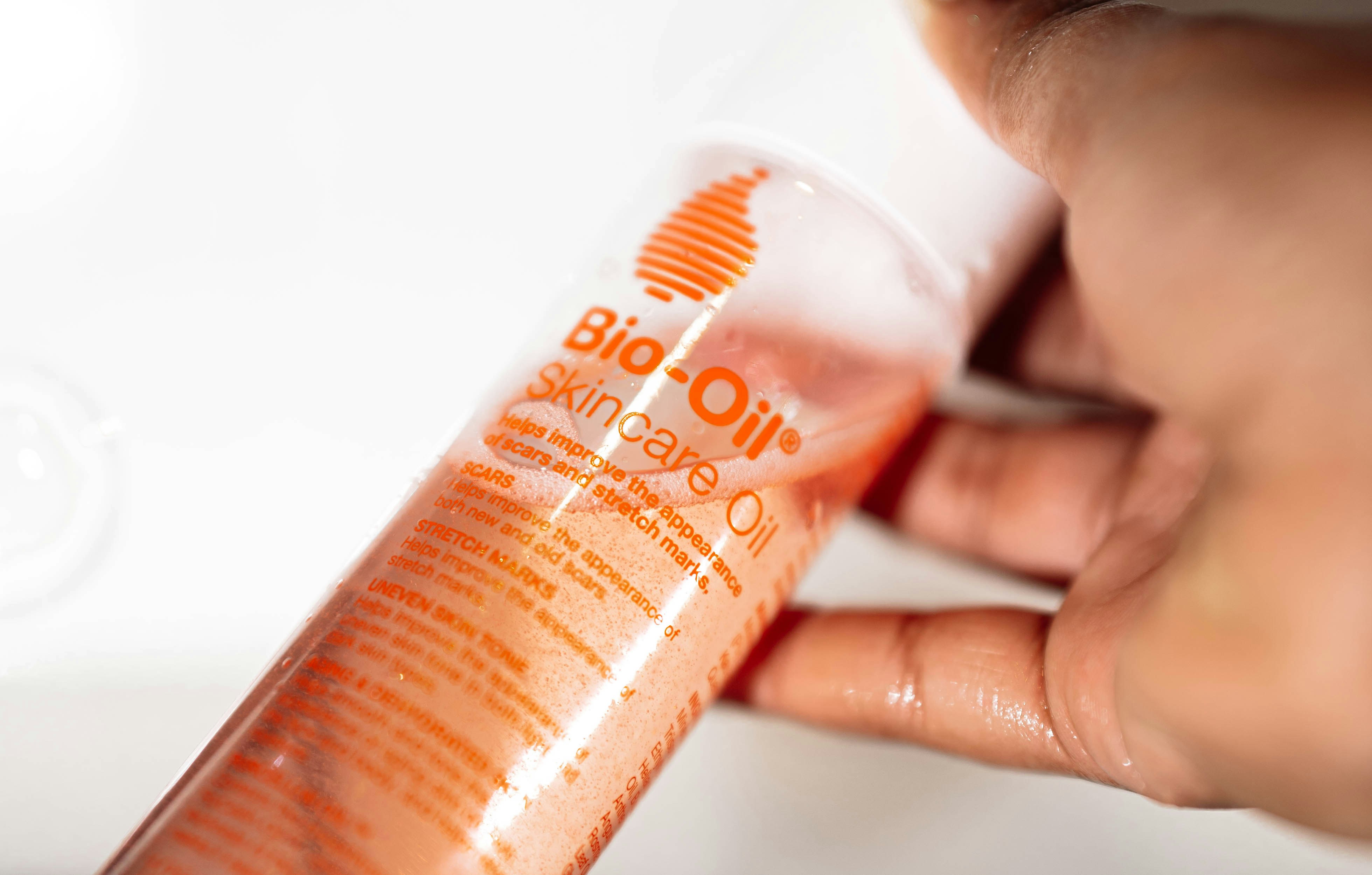 A woman applying moisturizer to her face.