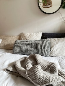 Bed with pillows and a knitted blanket