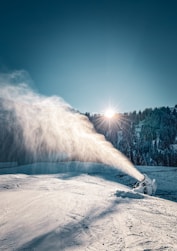 Snow cannon spraying snow on a sunny winter day