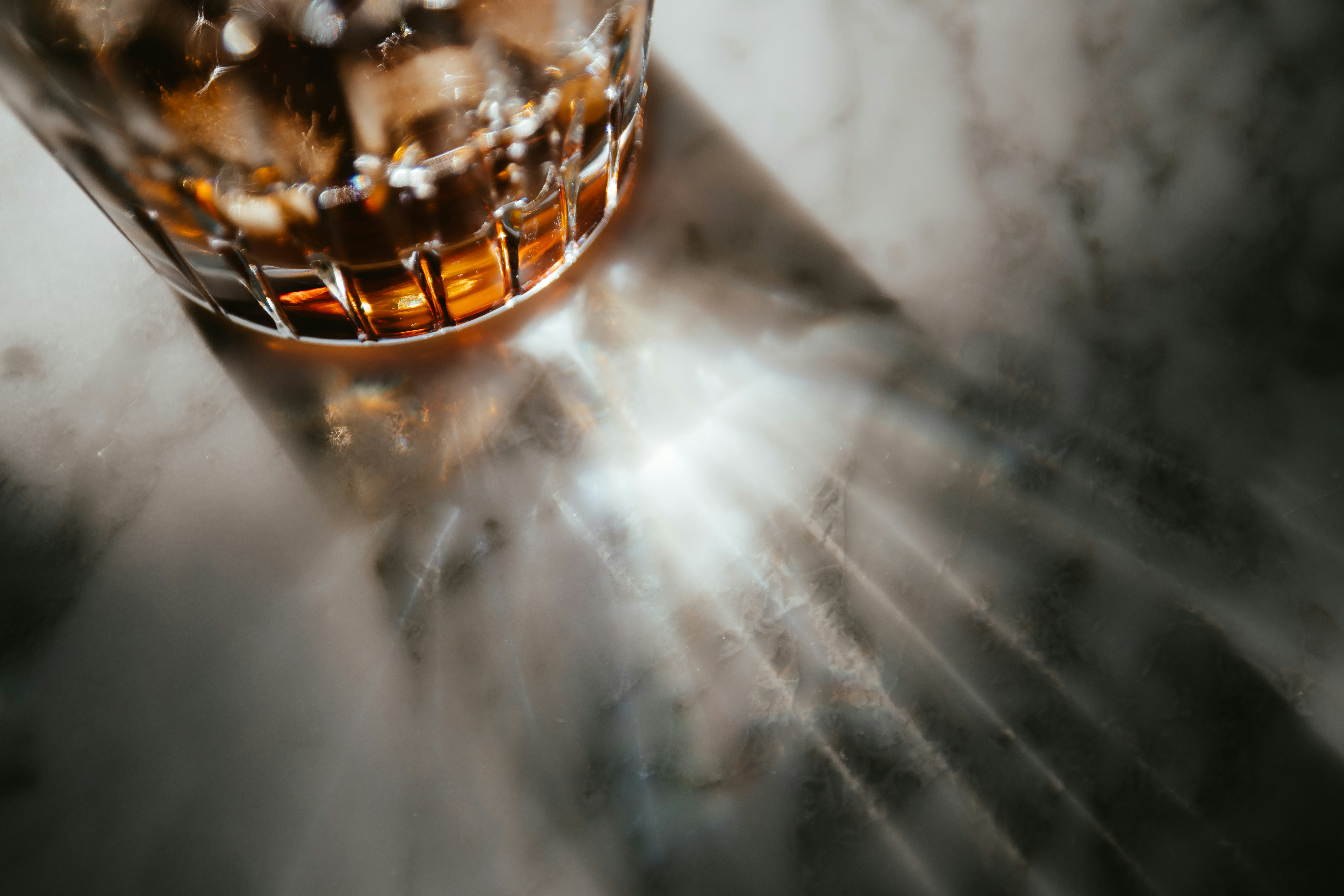 A glass of amber liquid with ice cubes.