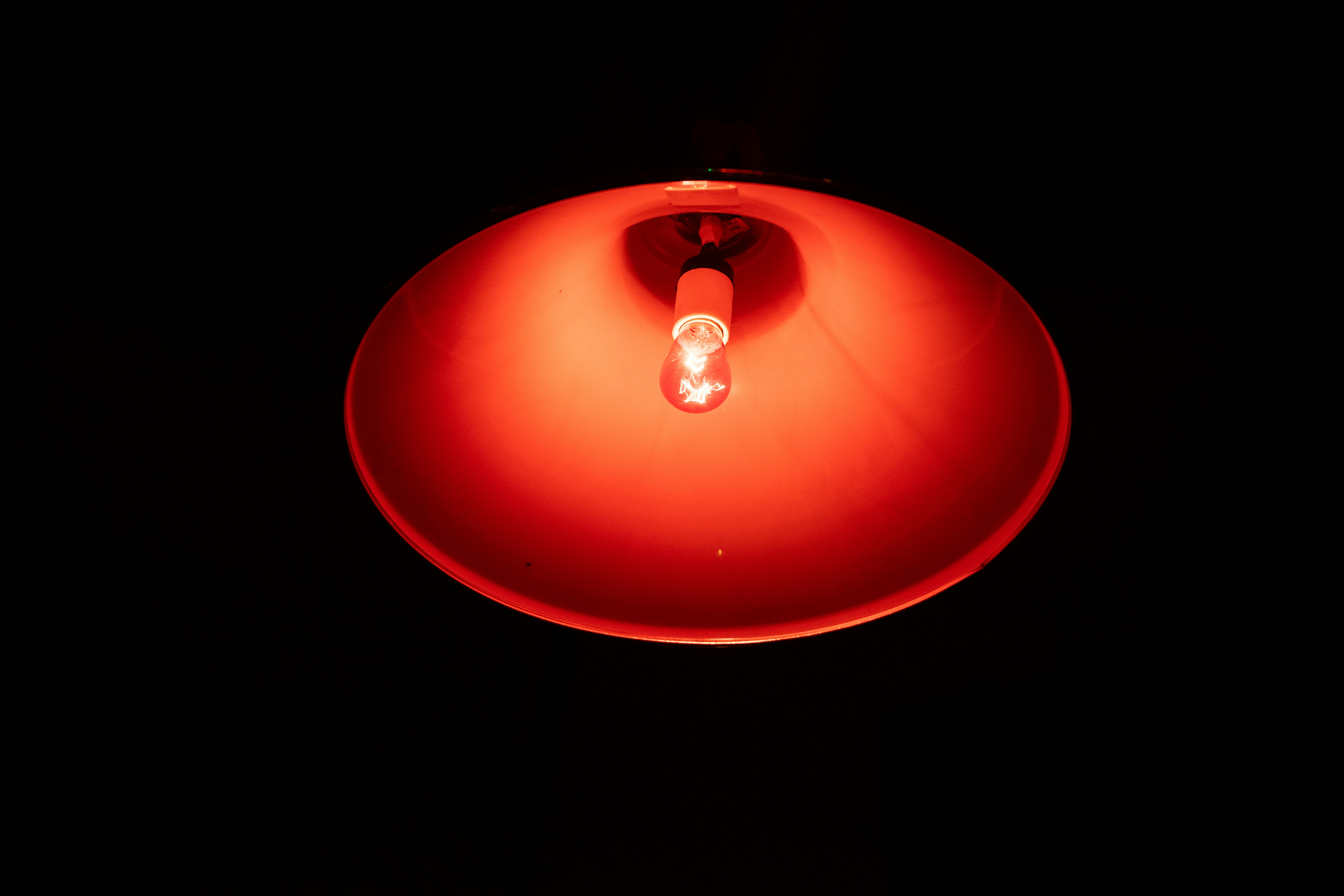 A red lamp with a lit bulb