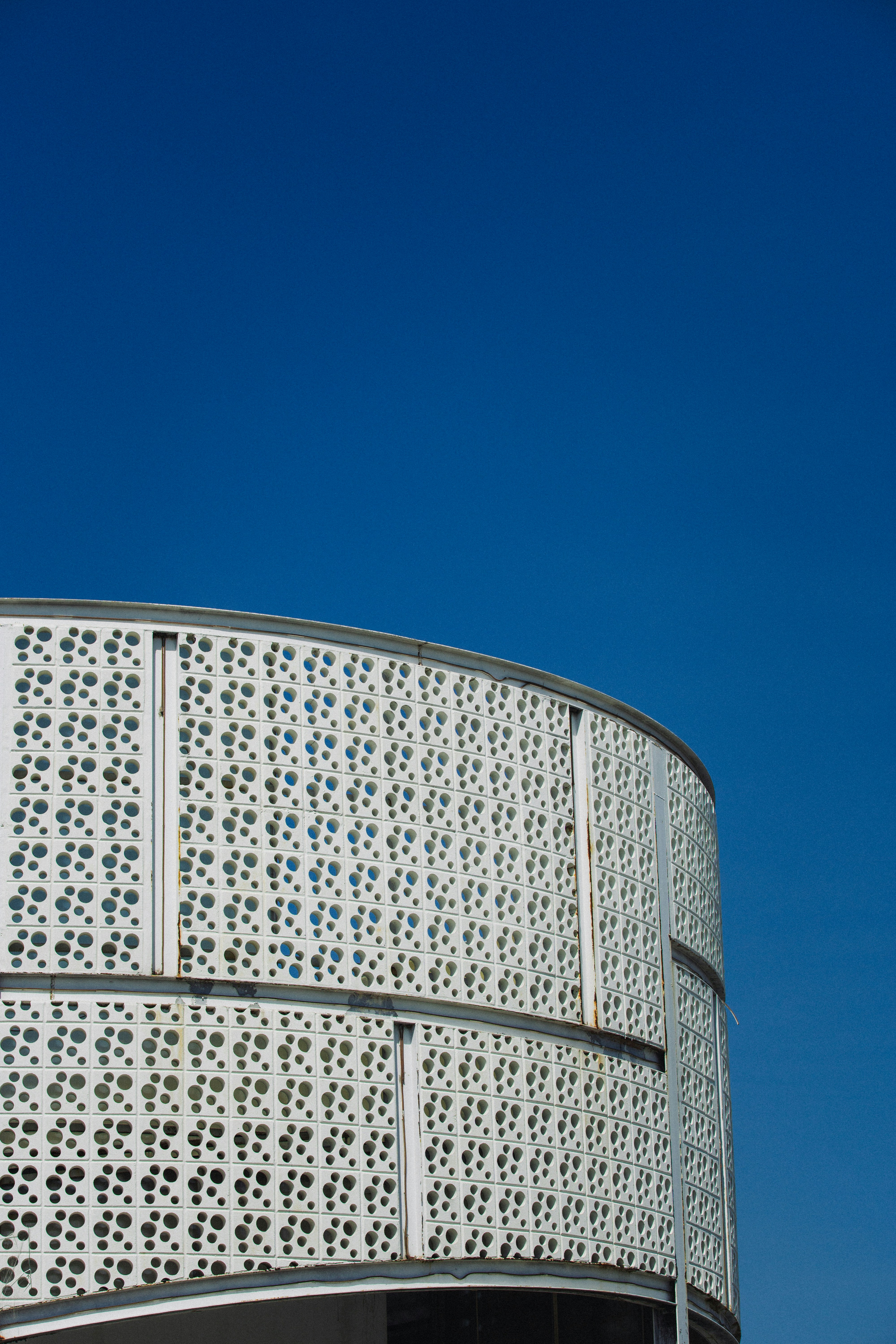 Modern building facade with circular patterns against blue sky